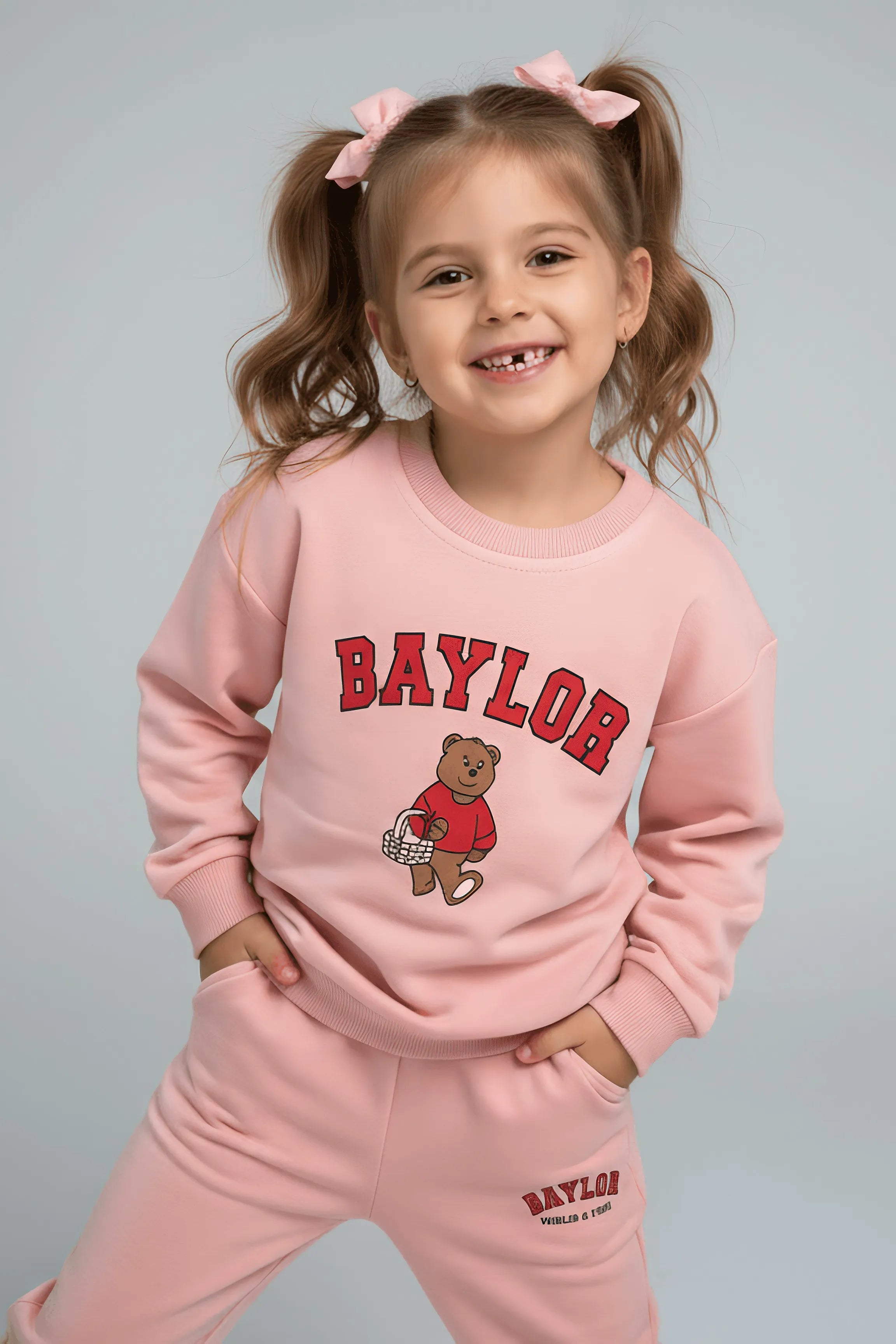 Child wearing a pink 'Baylor' Bubba's and Mama's outfit with a bear graphic on a gray background