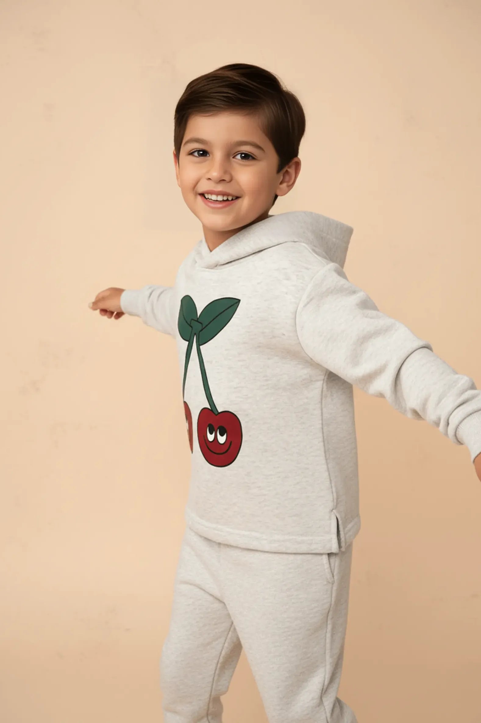 Child wearing a light gray Bubba's and Mama's hoodie with cherry design on a beige background
