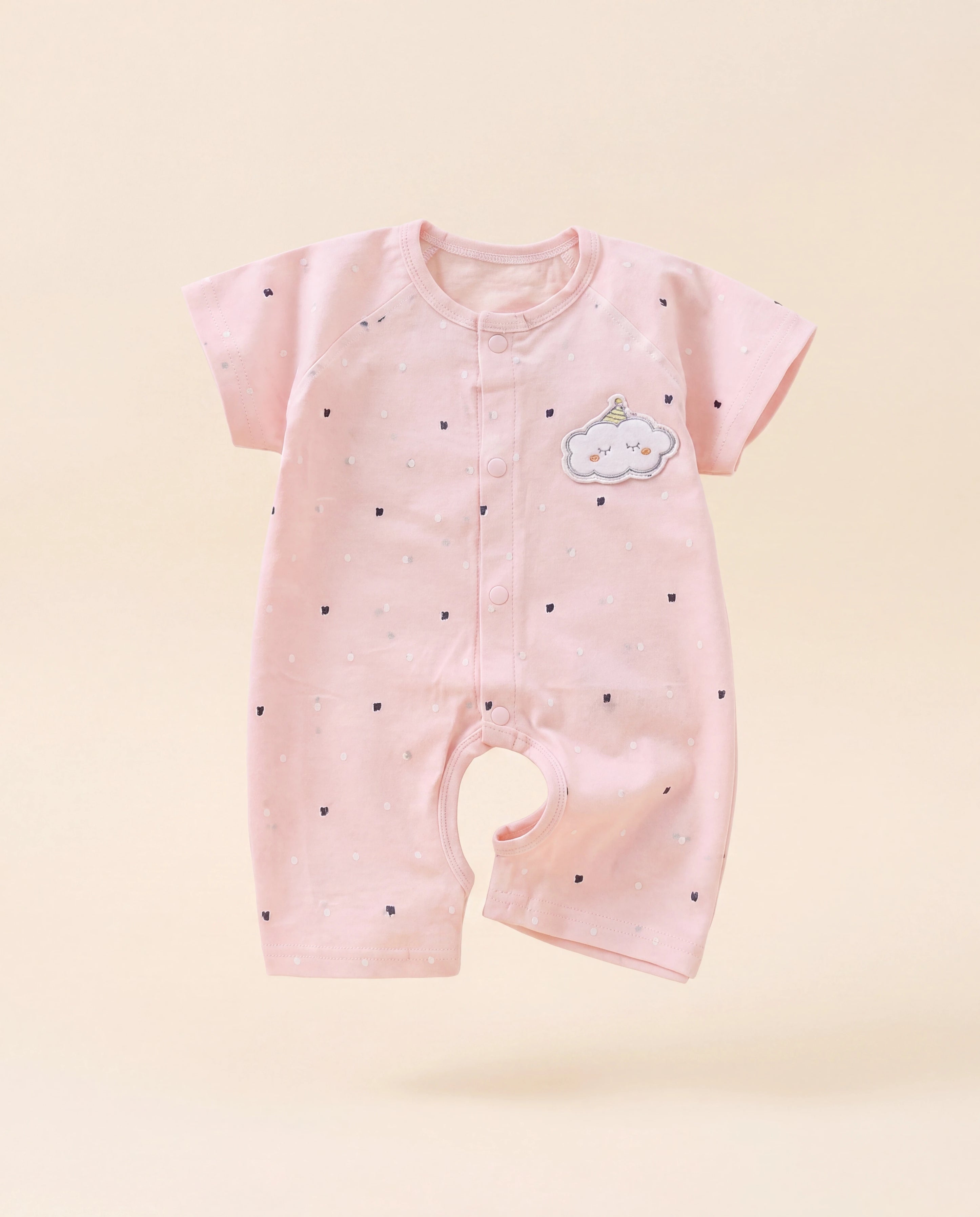 Pink baby romper with cloud design on a light pink background
