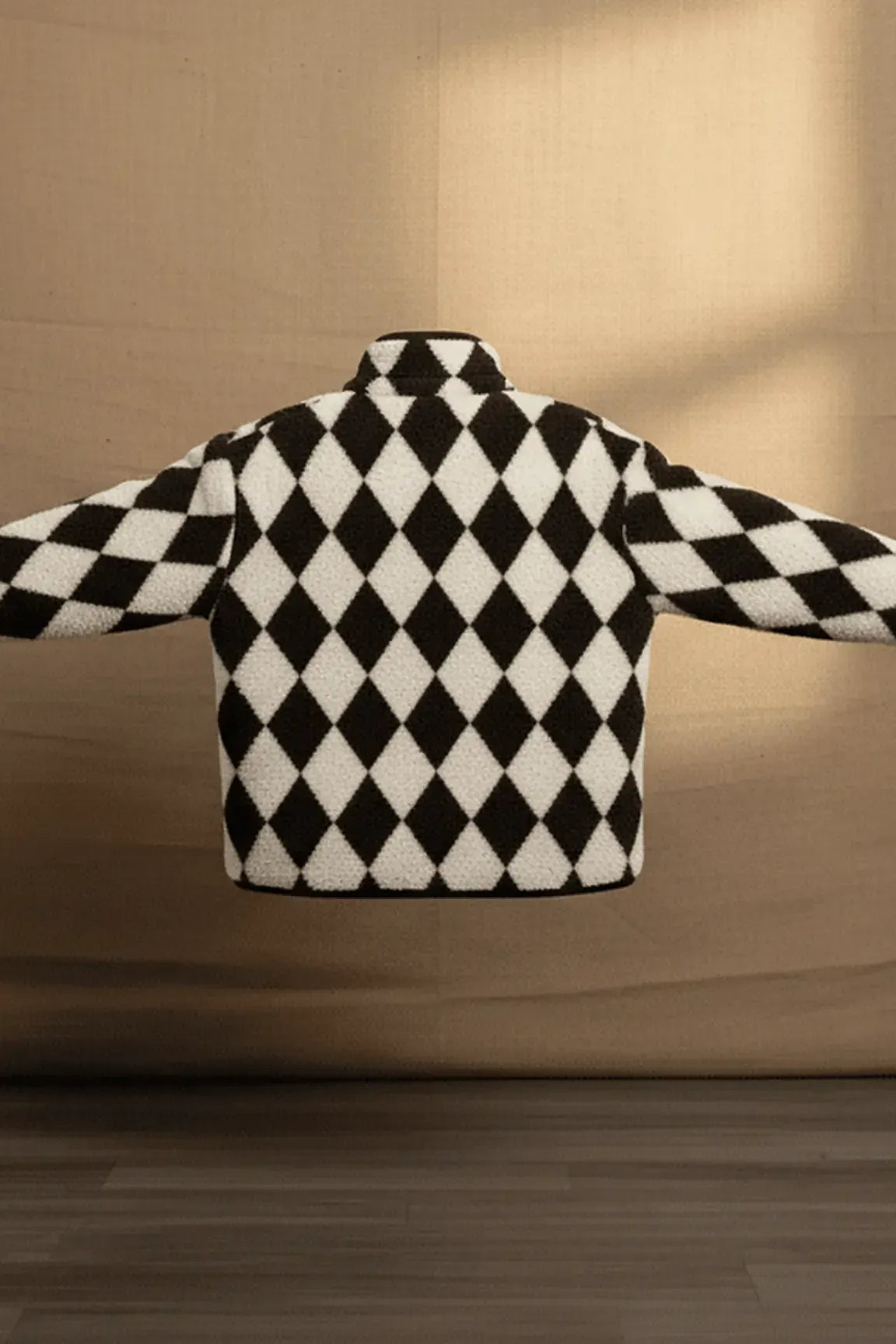 Black and white checkered sweater on a wooden floor with a beige wall background