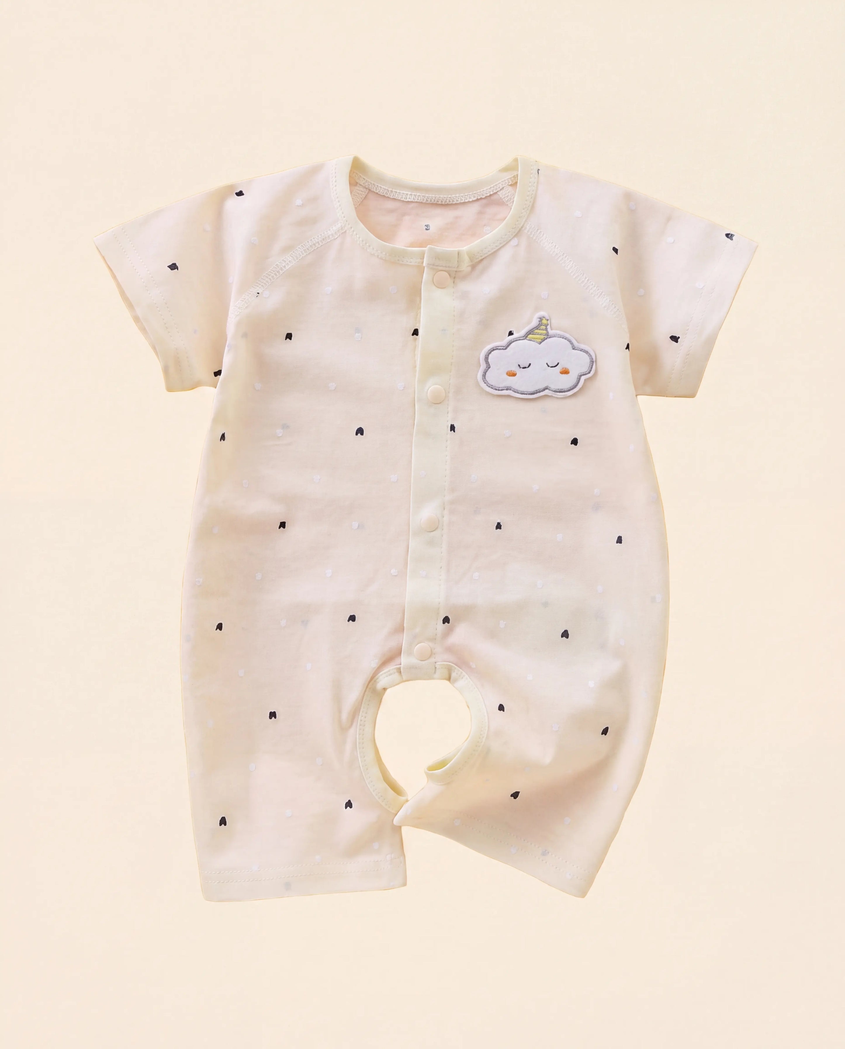 Baby romper with cloud design on a beige background