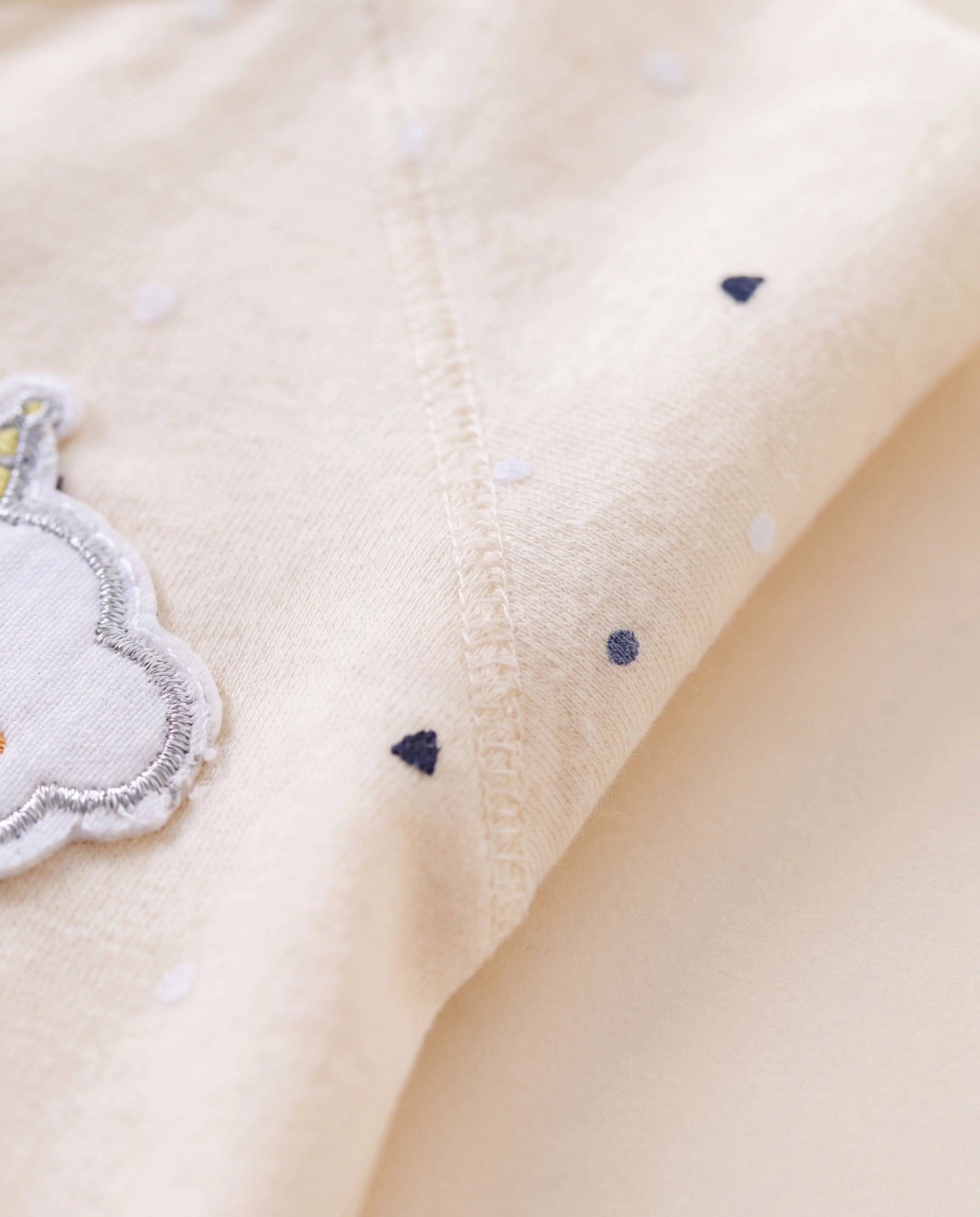 Close-up of a beige fabric with embroidered details on a soft background