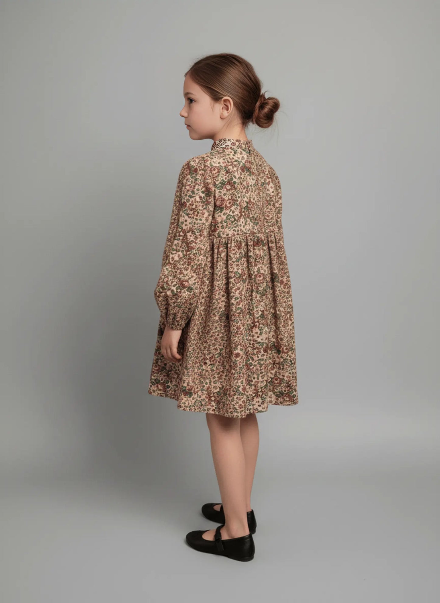 Young girl wearing a floral dress against a plain background