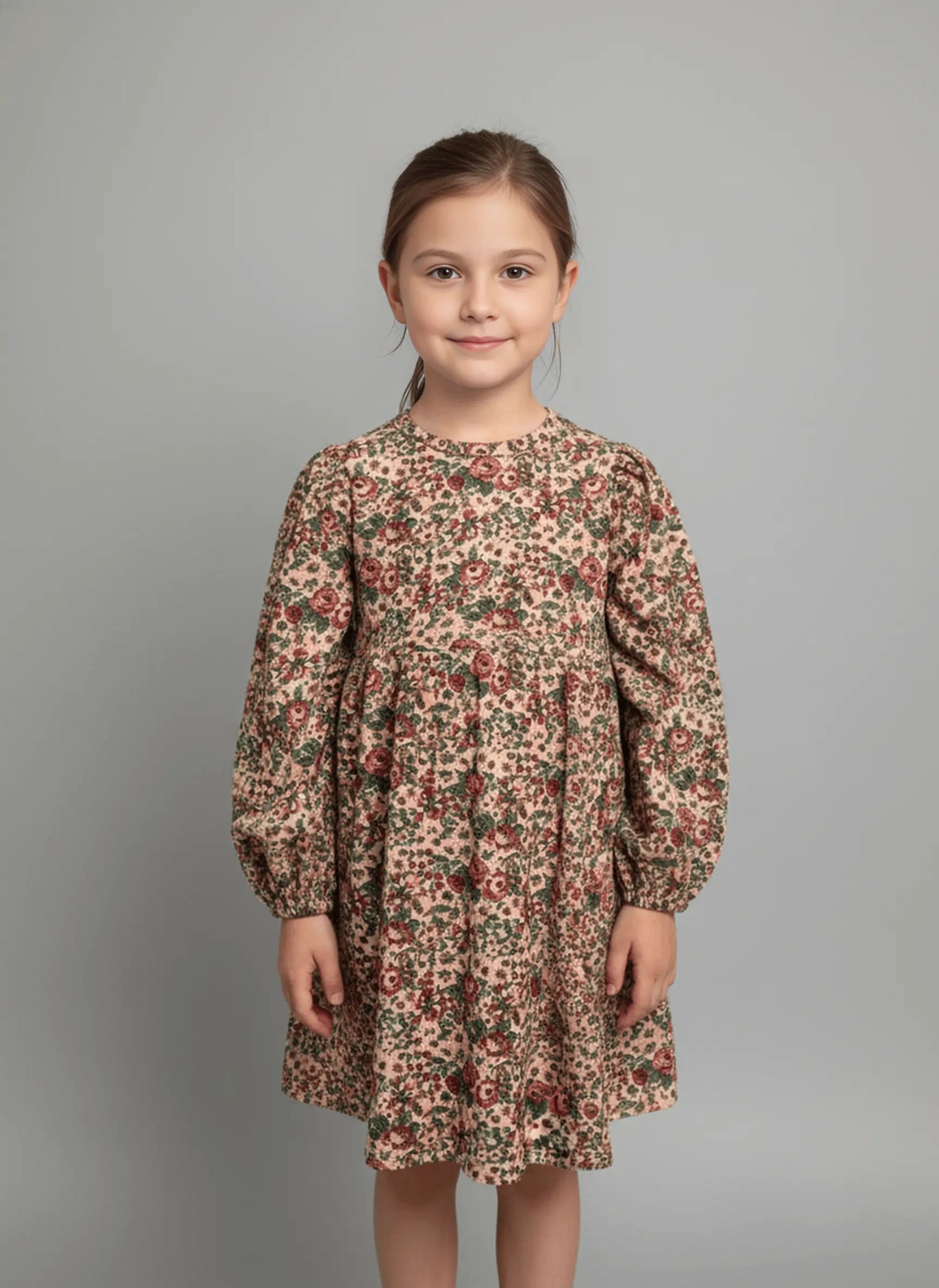 Young girl wearing a floral dress against a gray background