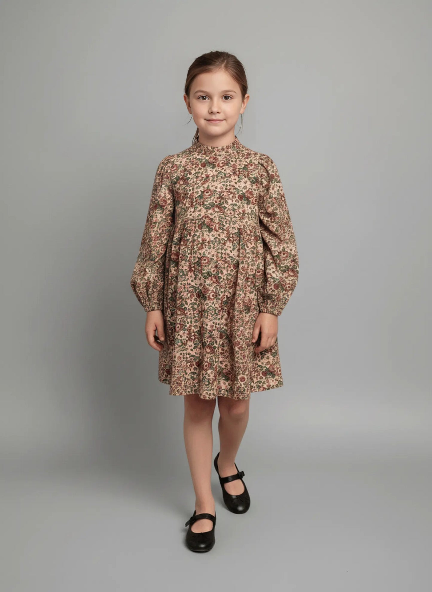 Young girl wearing a floral dress against a gray background