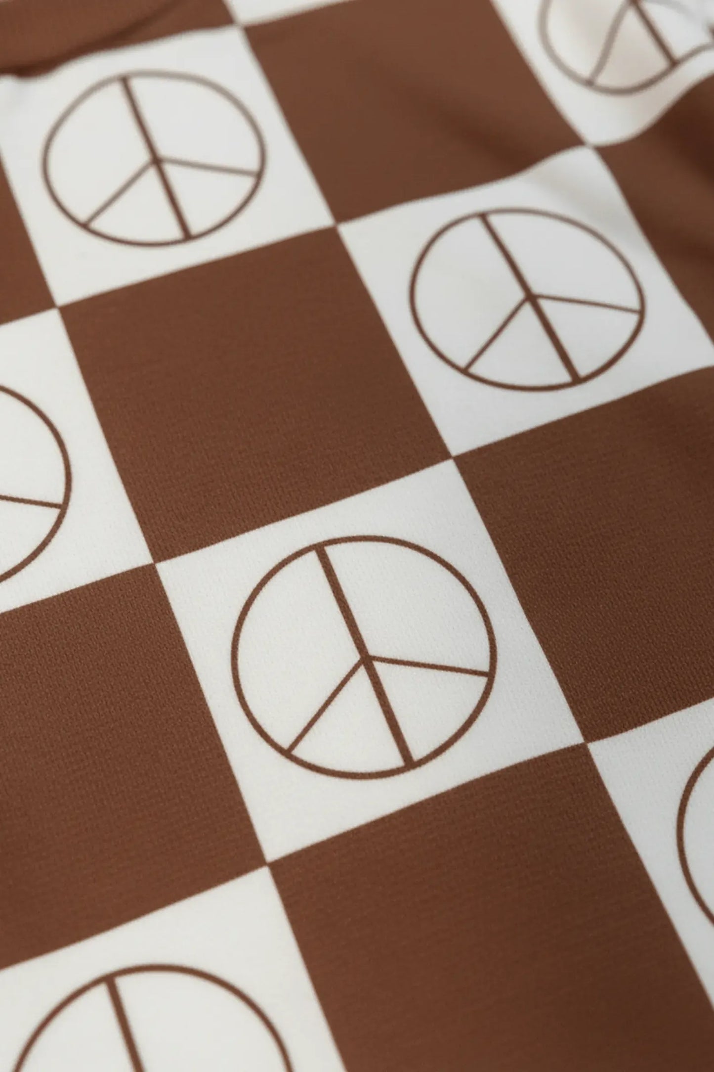 Checkered pattern with peace symbol on a brown and white background