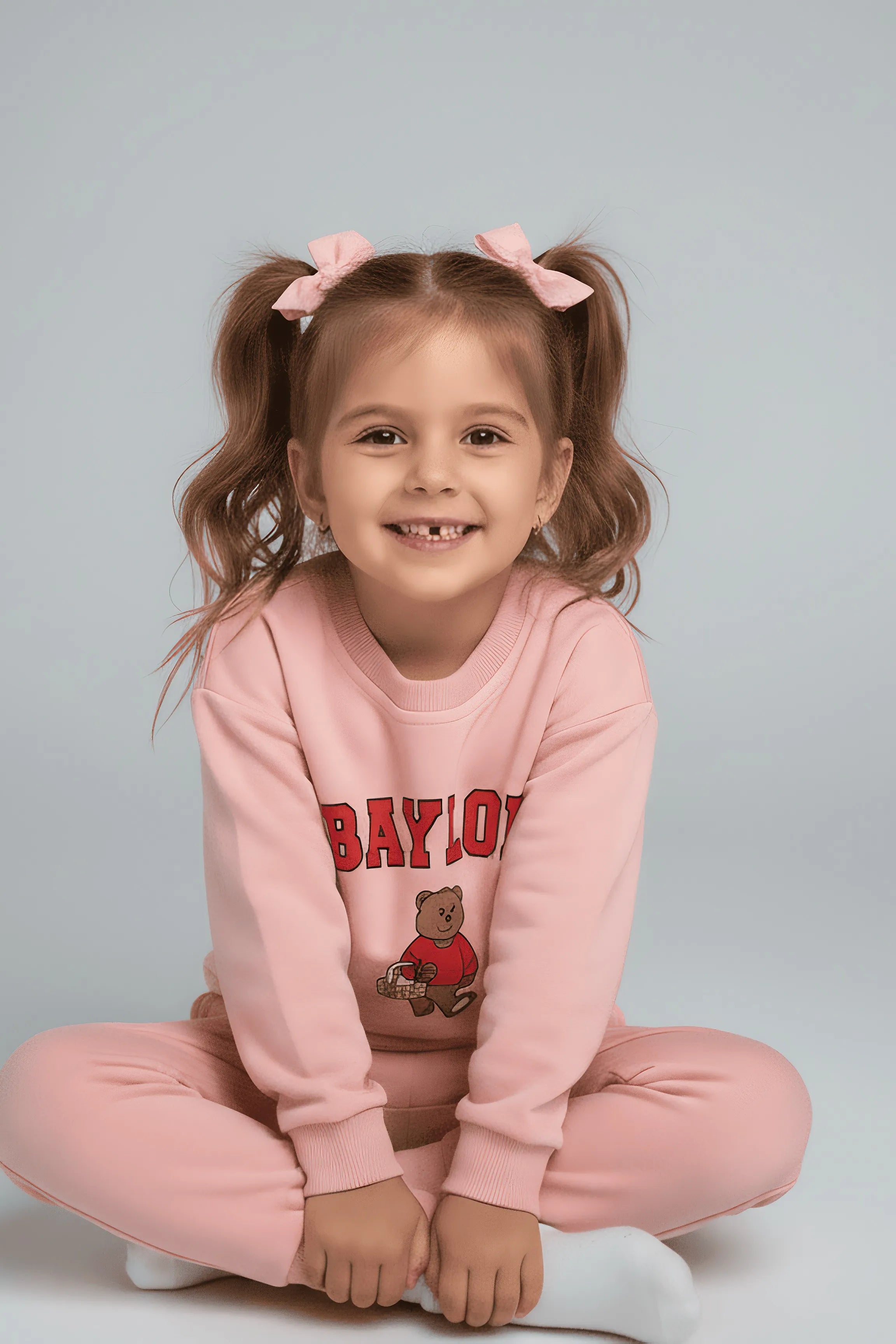 Child wearing a pink Bubba's and Mama's 'Baylor' sweatshirt with a teddy bear graphic on a gray background
