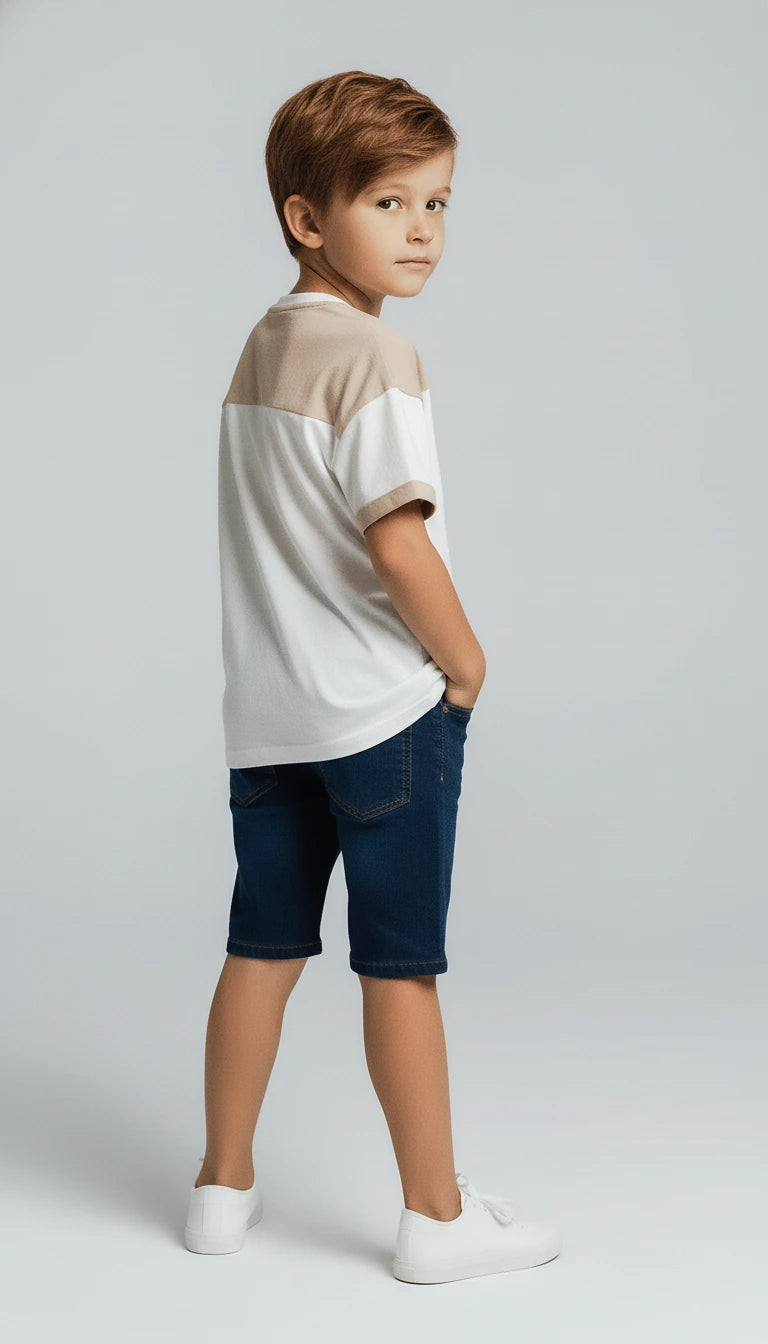 Young boy wearing a two-tone shirt and blue shorts on a white background