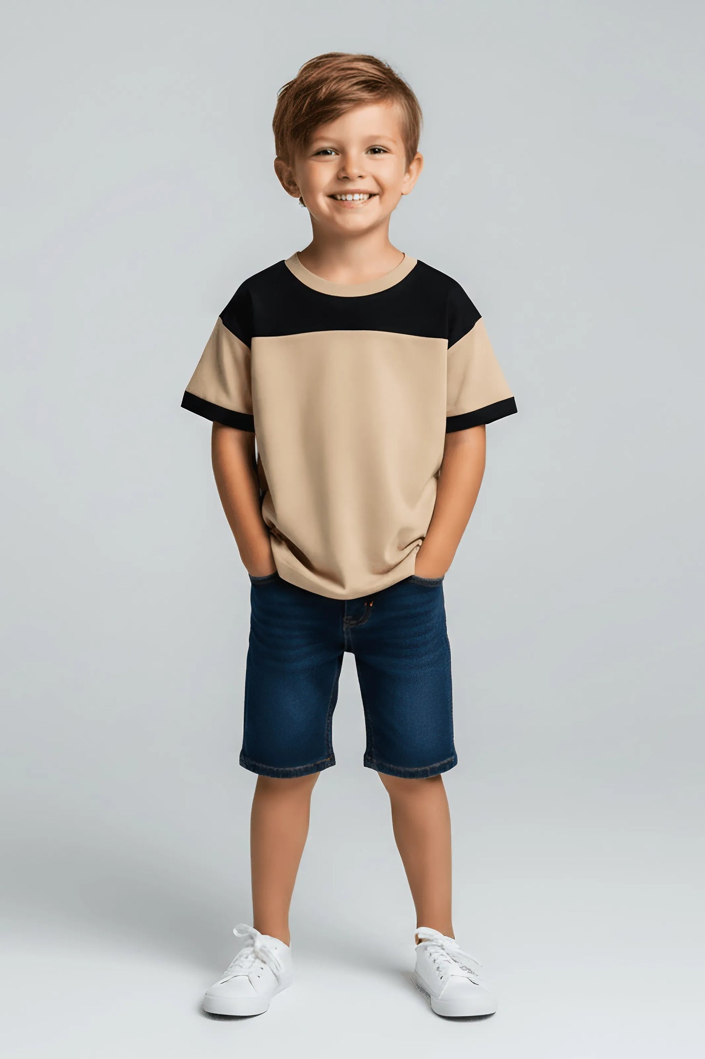 Child wearing a Bubba's and Mama's beige and black shirt with blue shorts on a gray background