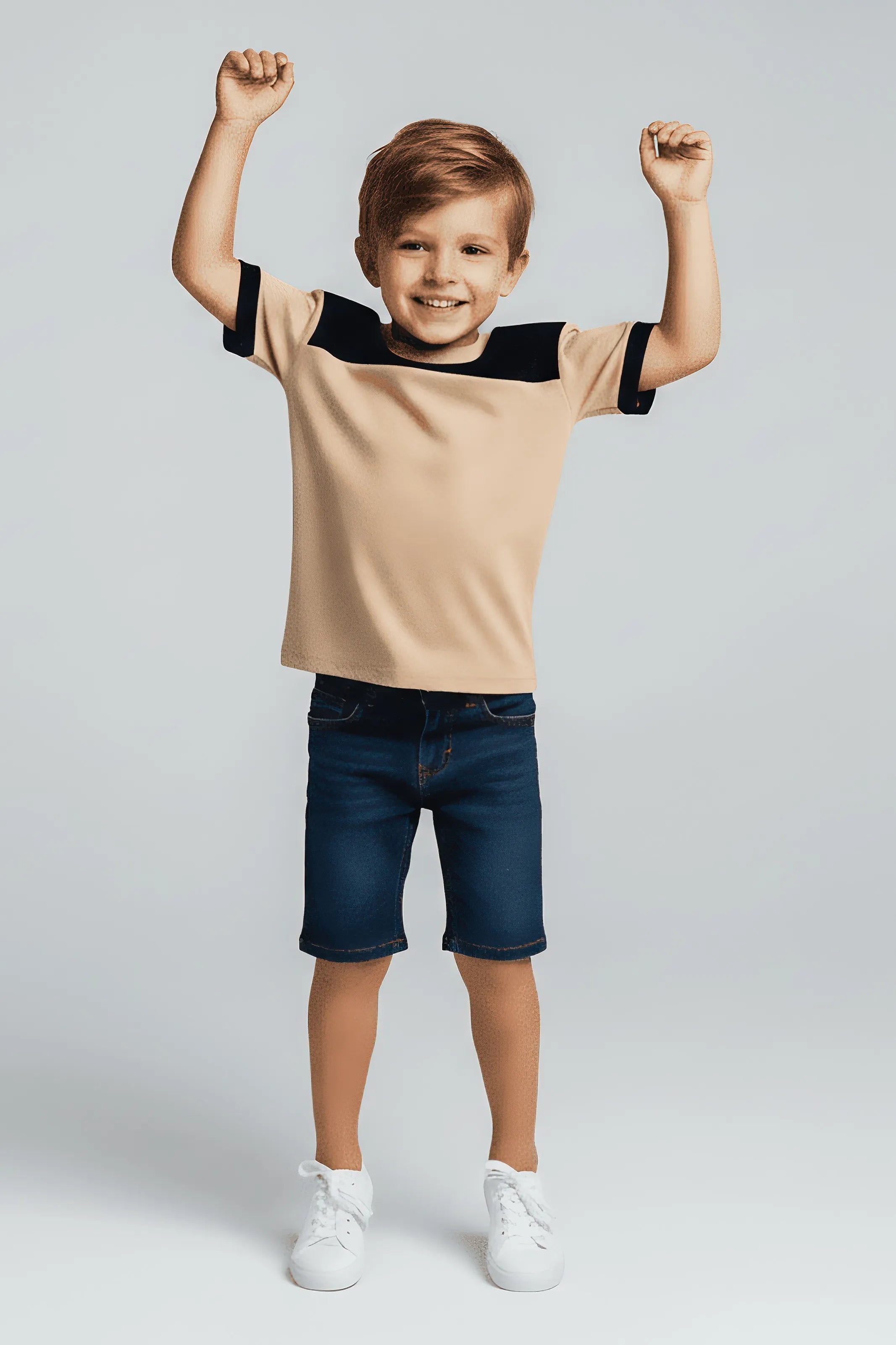 Child wearing a Bubba's and Mama's beige and black shirt with blue shorts on a white background