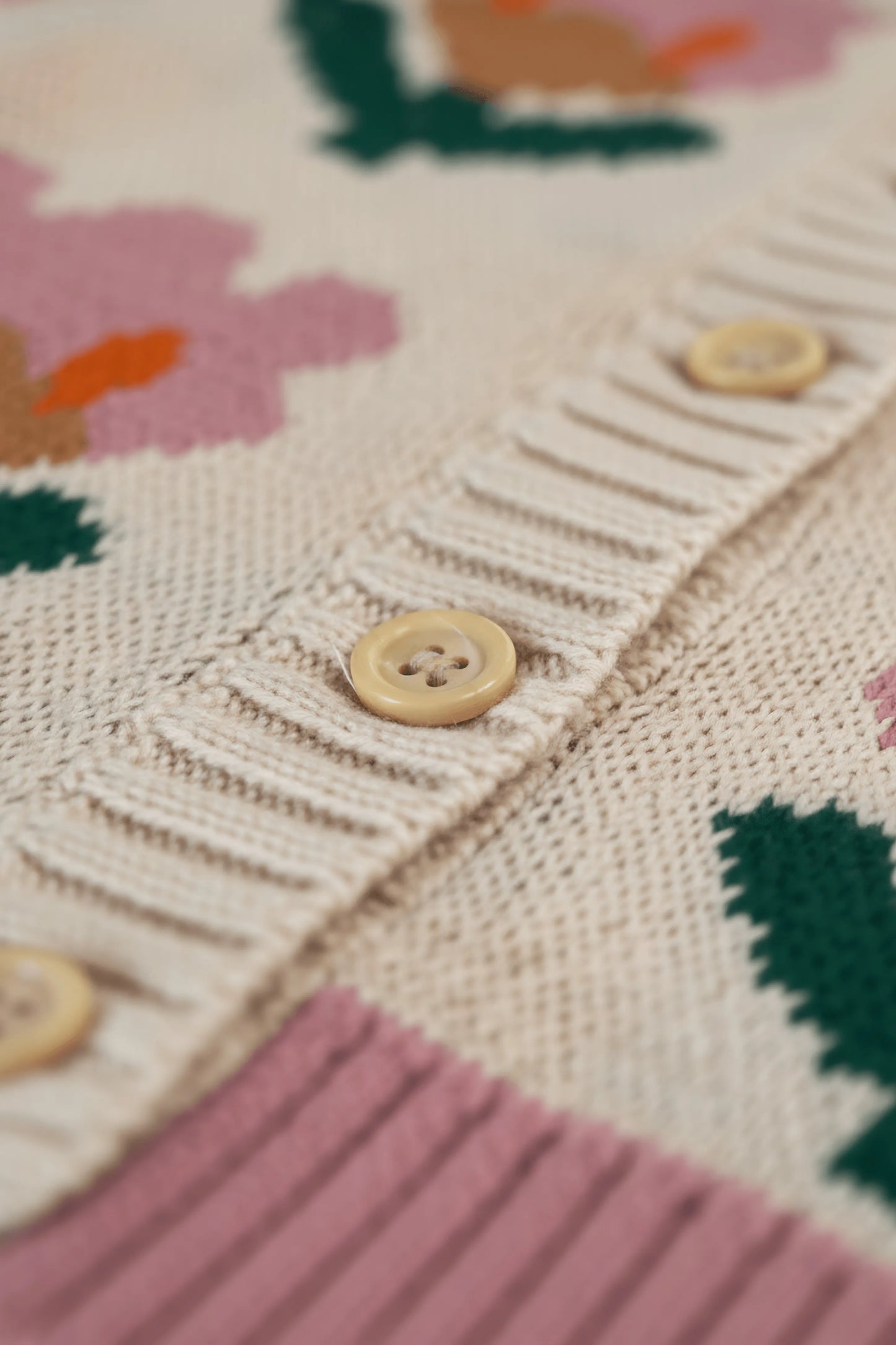 Close-up of a Bubba's and Mama's knitted garment with buttons on a colorful background