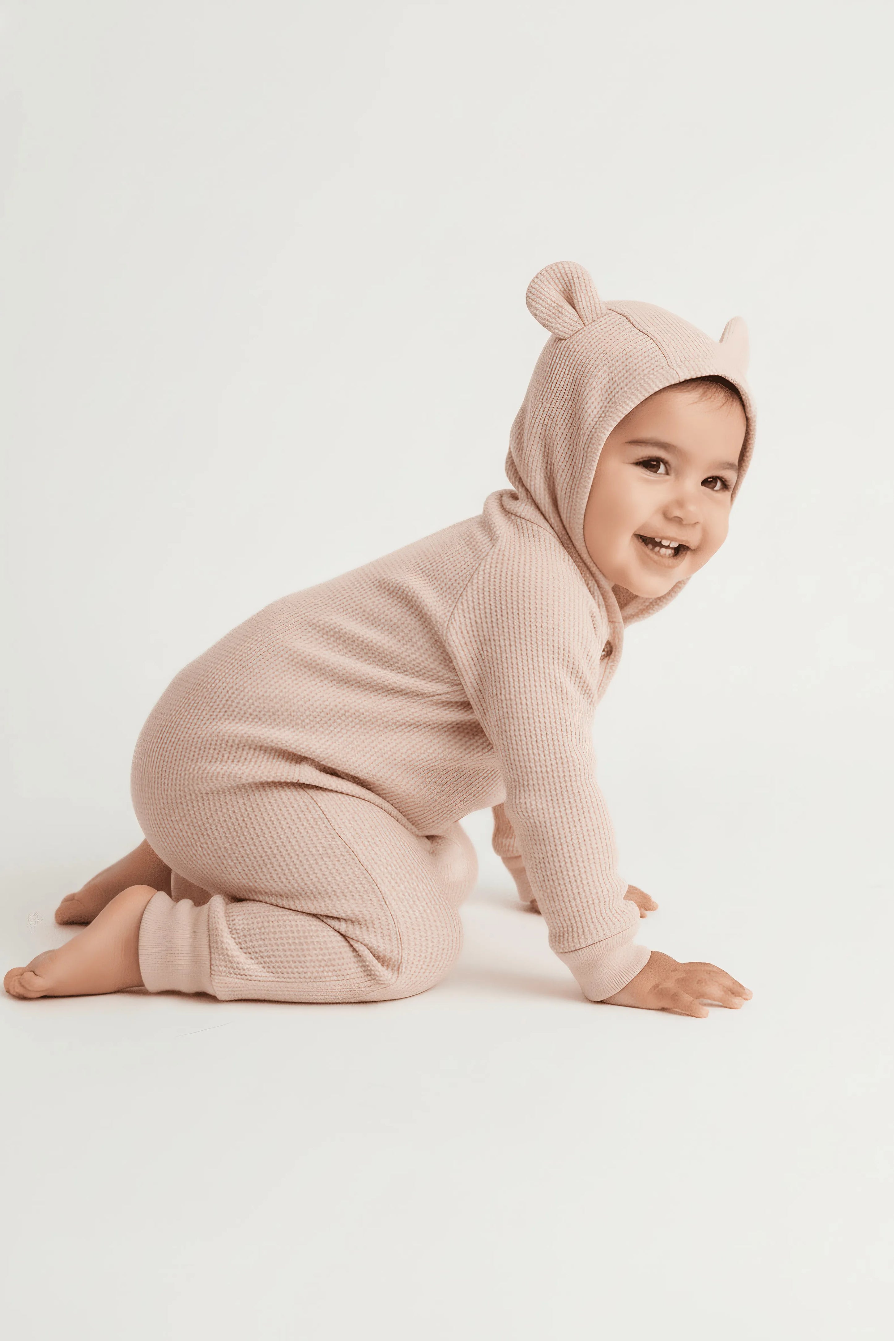 Baby in a pink Bubba's and Mama's bear onesie on a white background