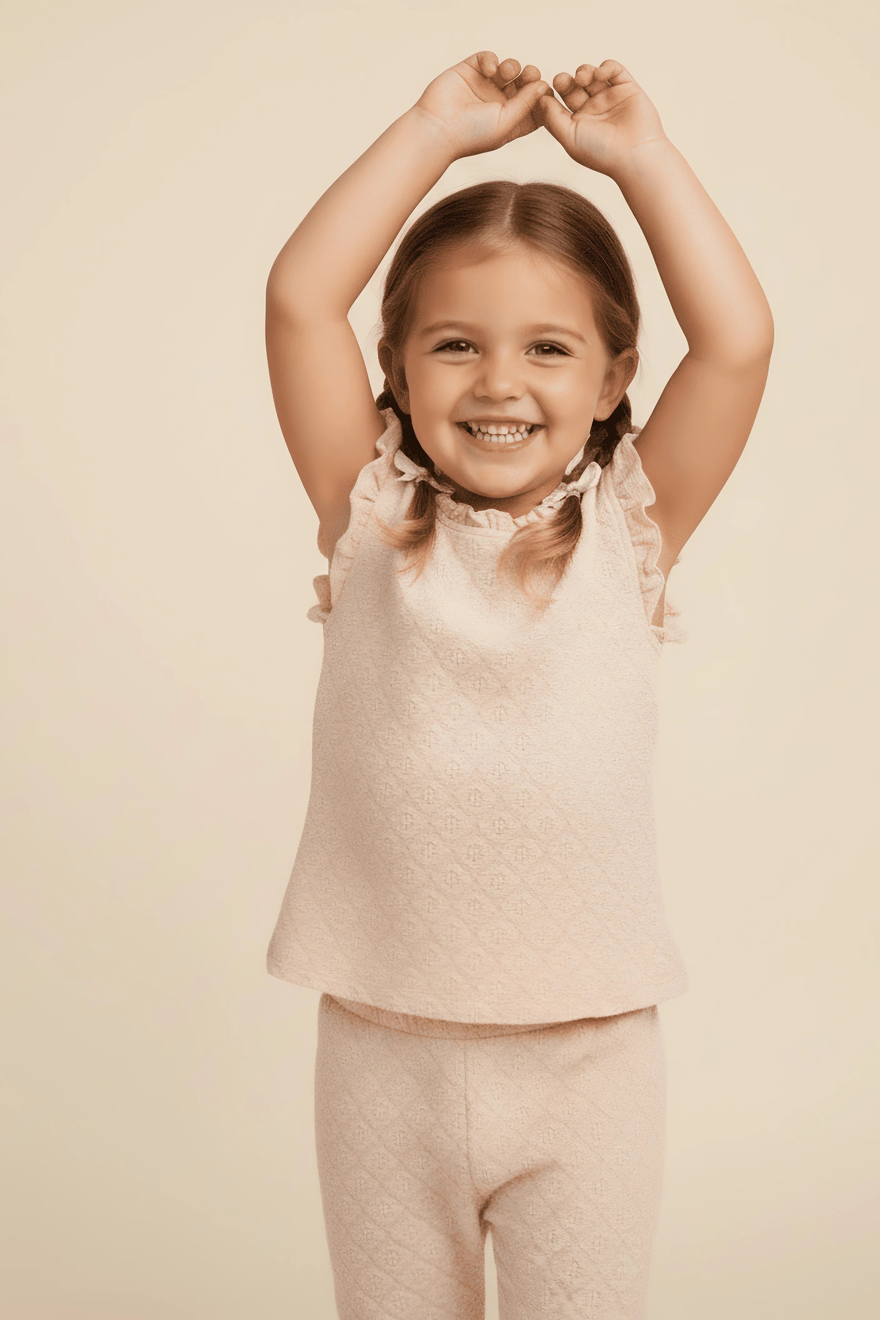 Young girl in a matching Bubba's and Mama's top and pants set against a beige background