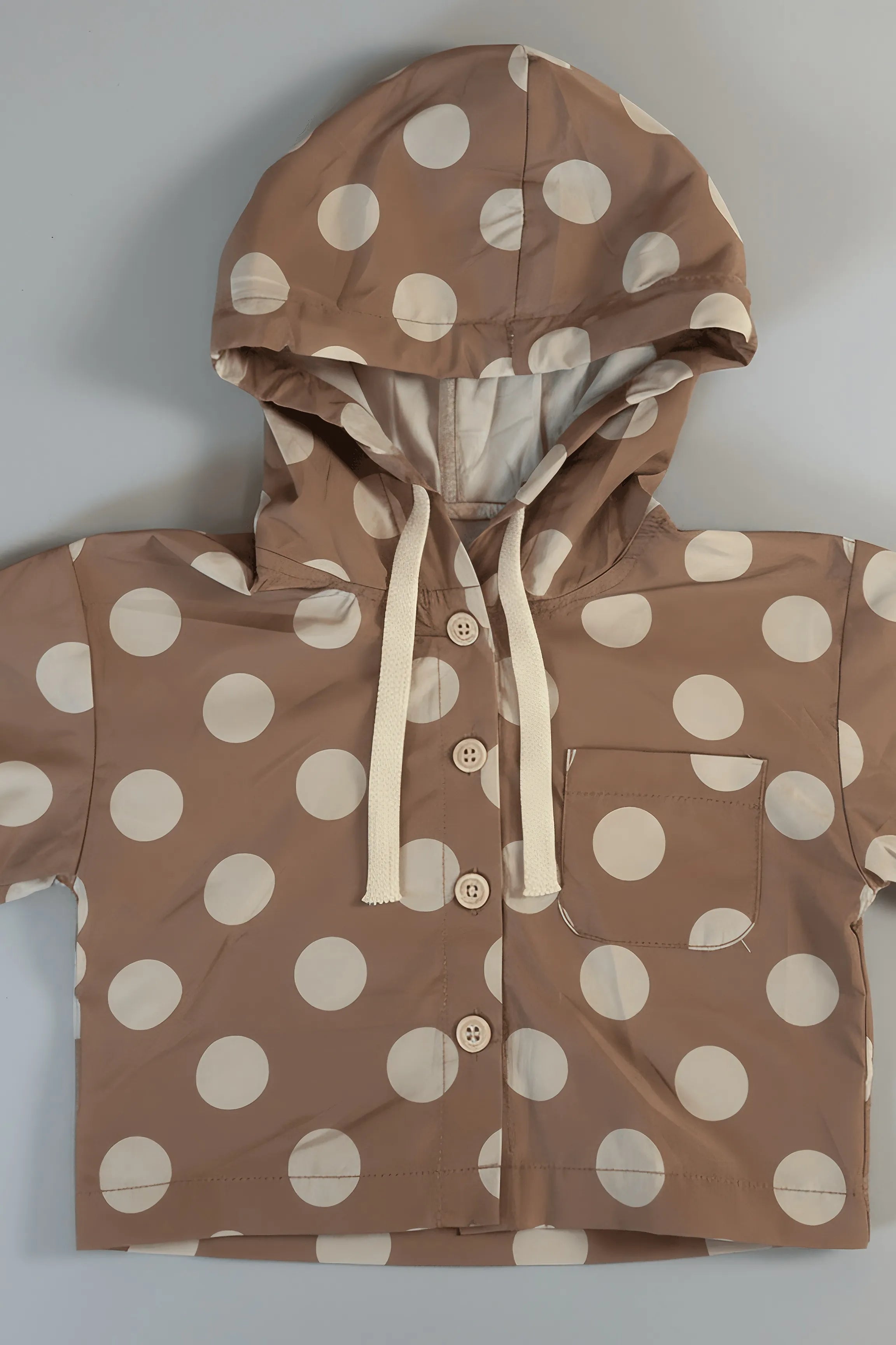 Brown Bubba's and Mama's raincoat with white polka dots on a light gray background