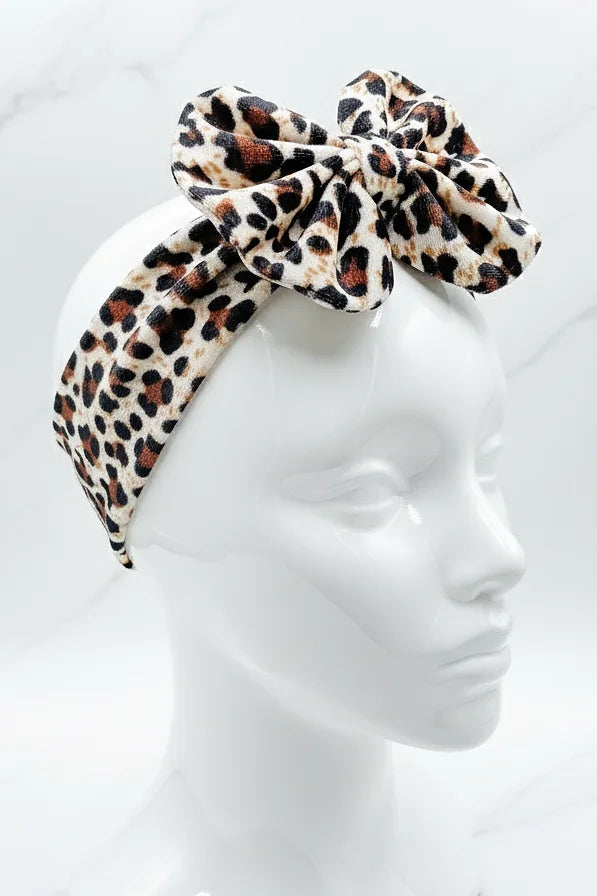Leopard print headscarf with a large bow on a mannequin head against a white background
