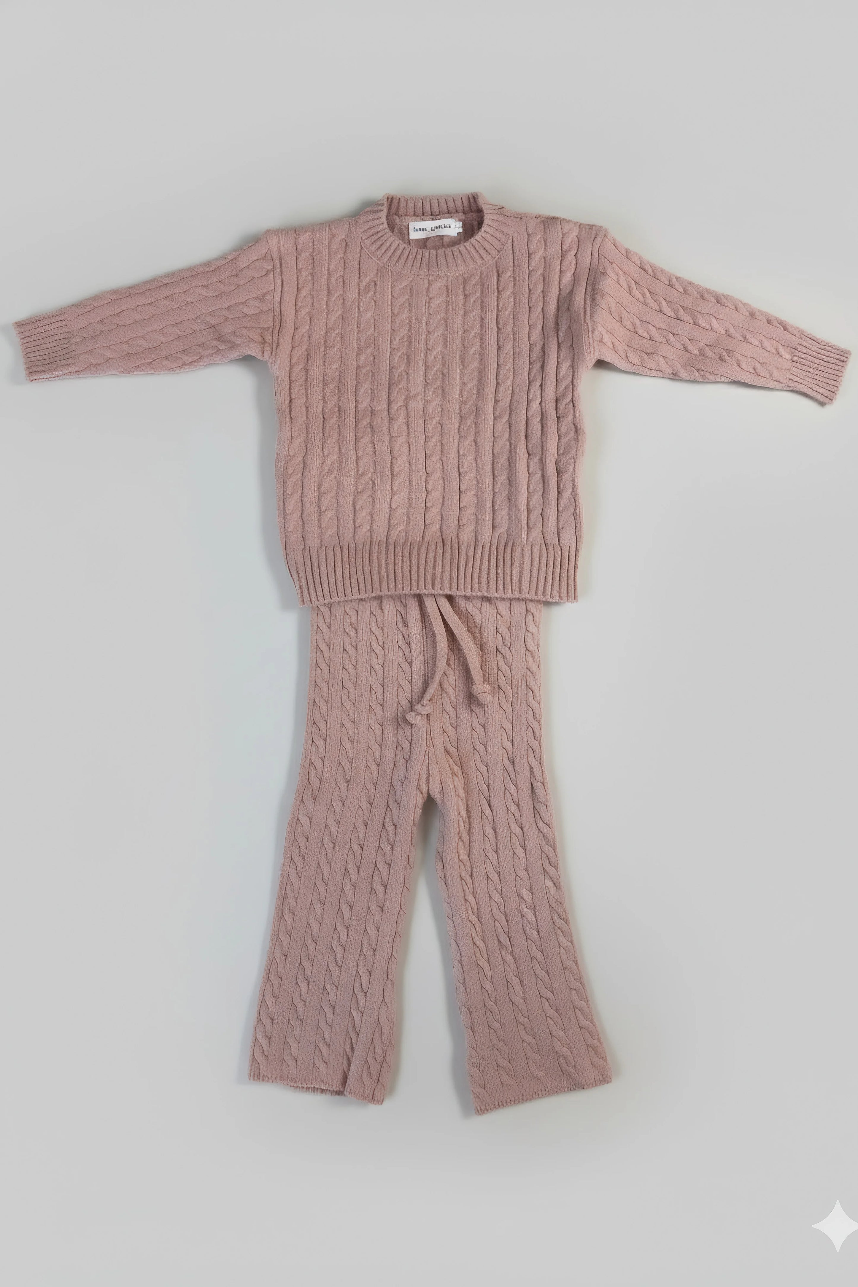 Pink cable knit Bubba's and Mama's sweater and pants set on a light gray background