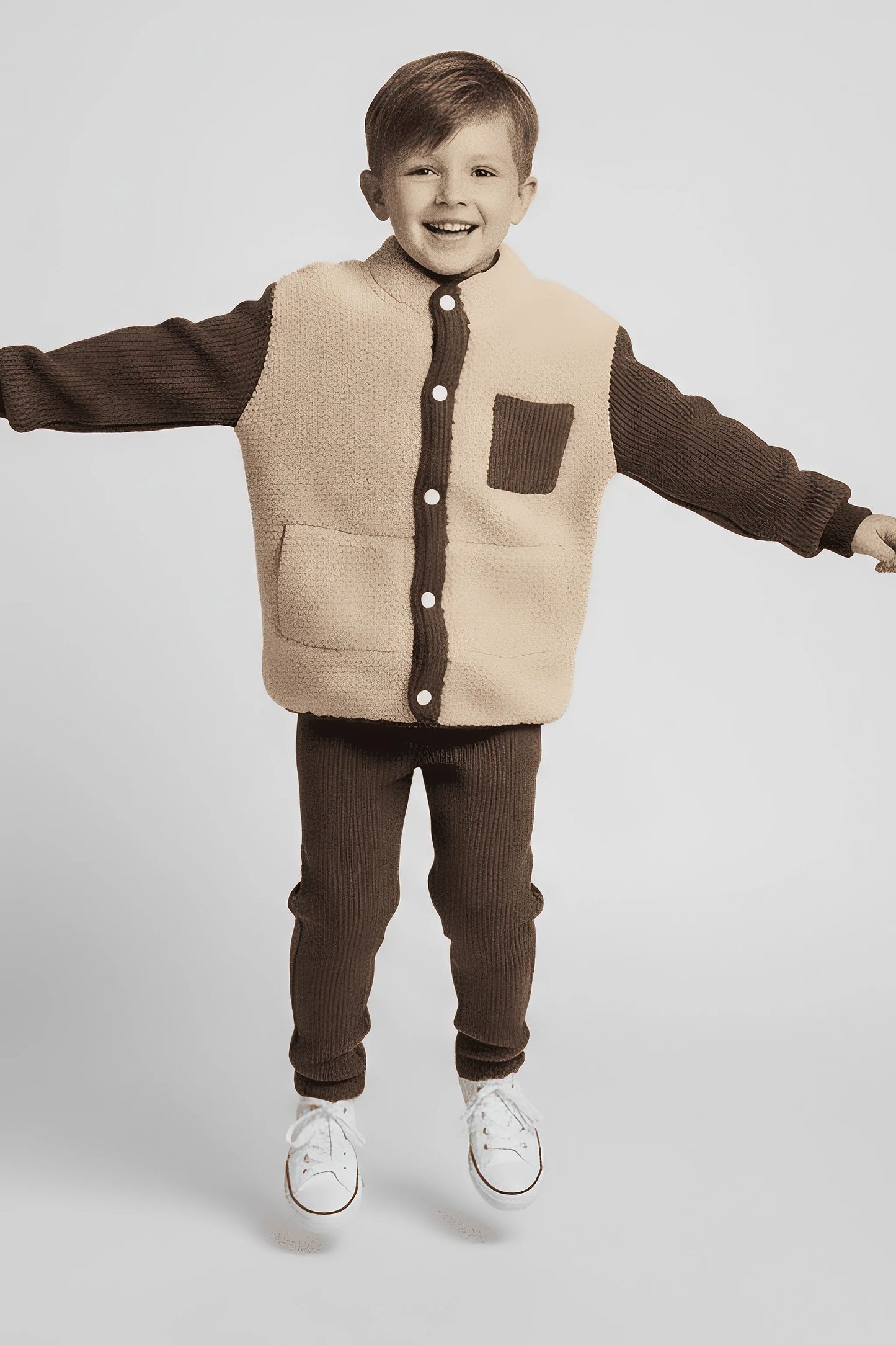 Child wearing a brown and beige Bubba's and Mama's outfit with a vest on a white background