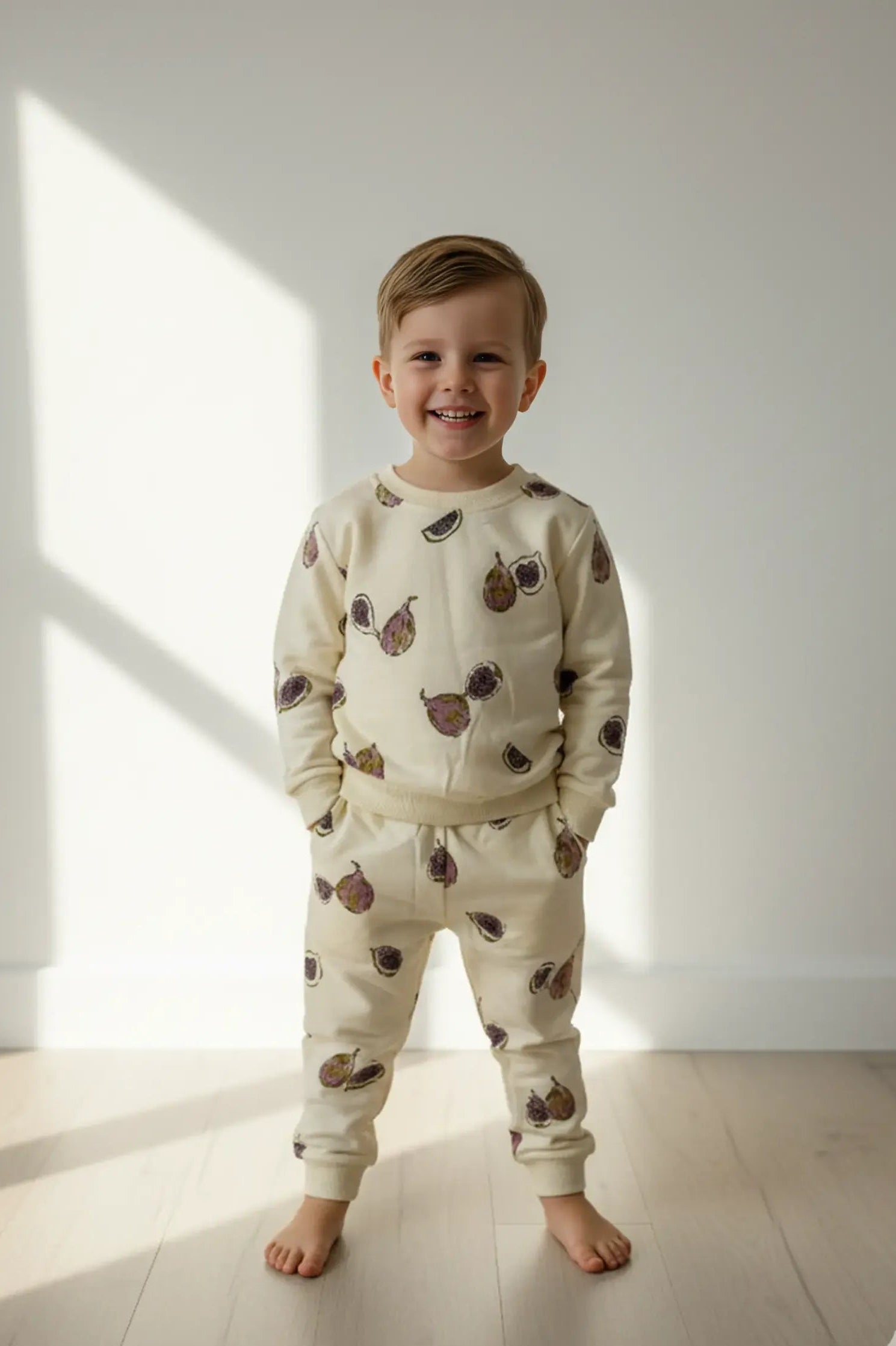 Child wearing a cream-colored Bubba's and Mama's pajama set with animal prints standing in a well-lit room.