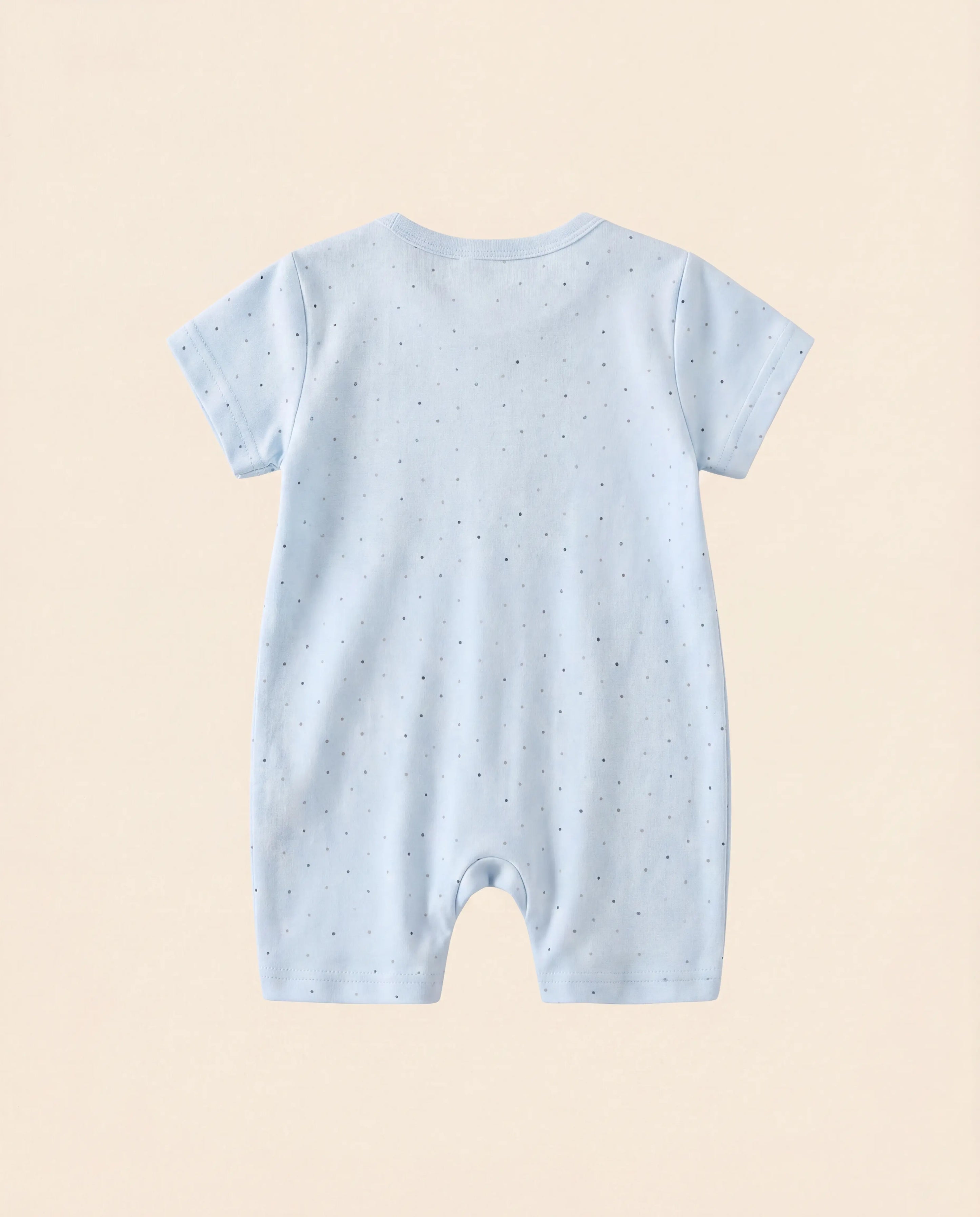 Light blue baby romper with star pattern on a beige background