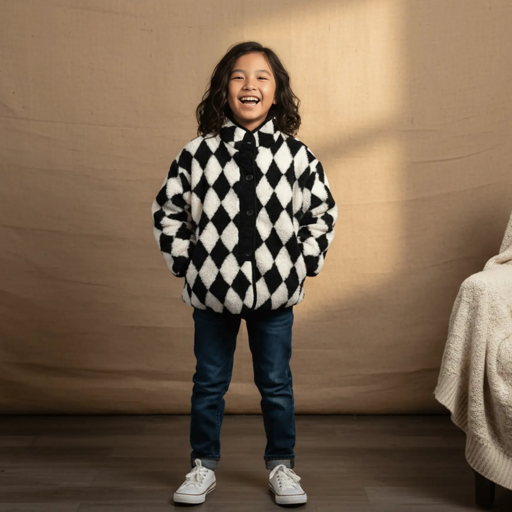 Child wearing a black and white checkered sweater with a brown background