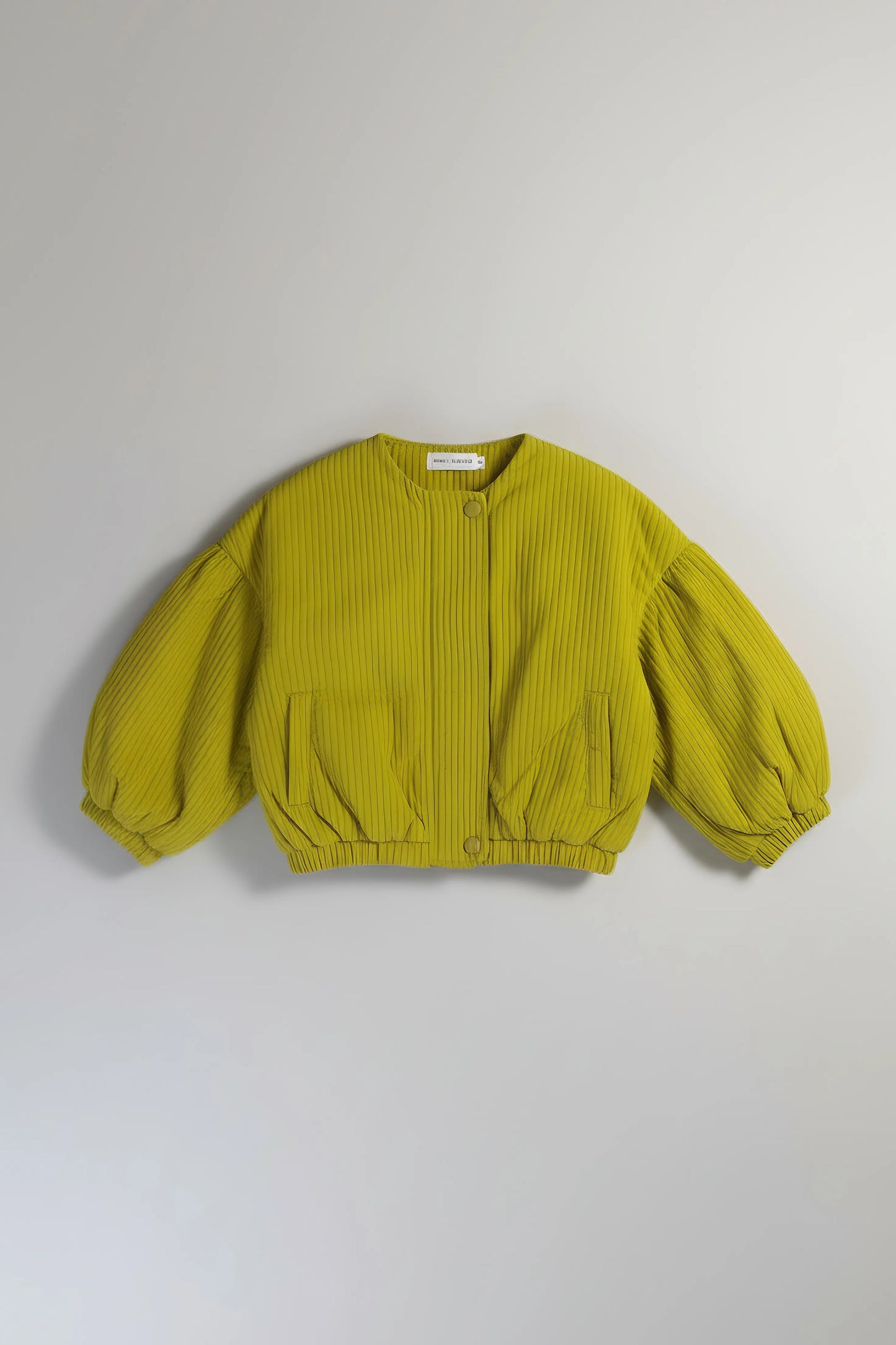 Green ribbed sweater with balloon sleeves on a light gray background