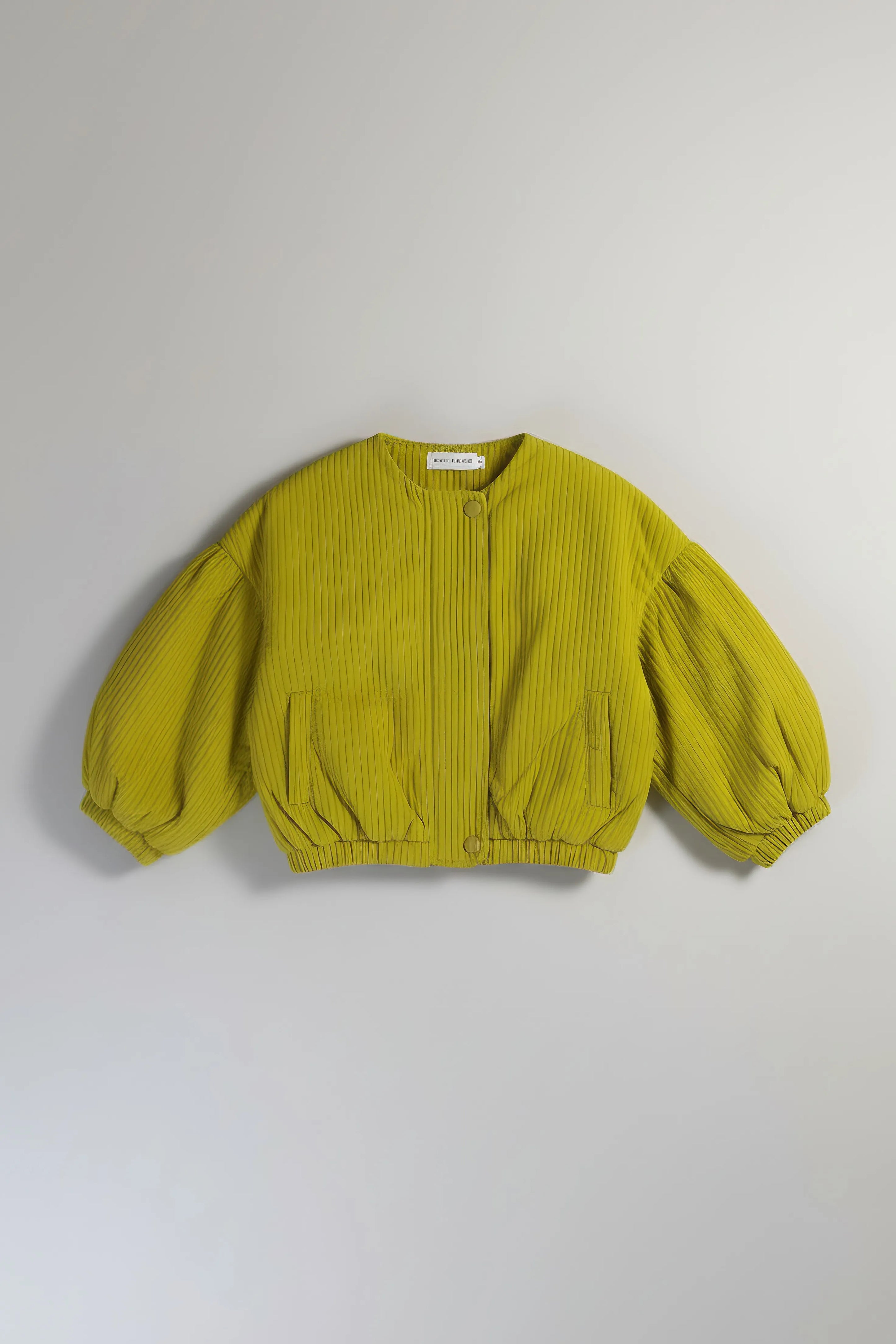 Green ribbed sweater with balloon sleeves on a light gray background