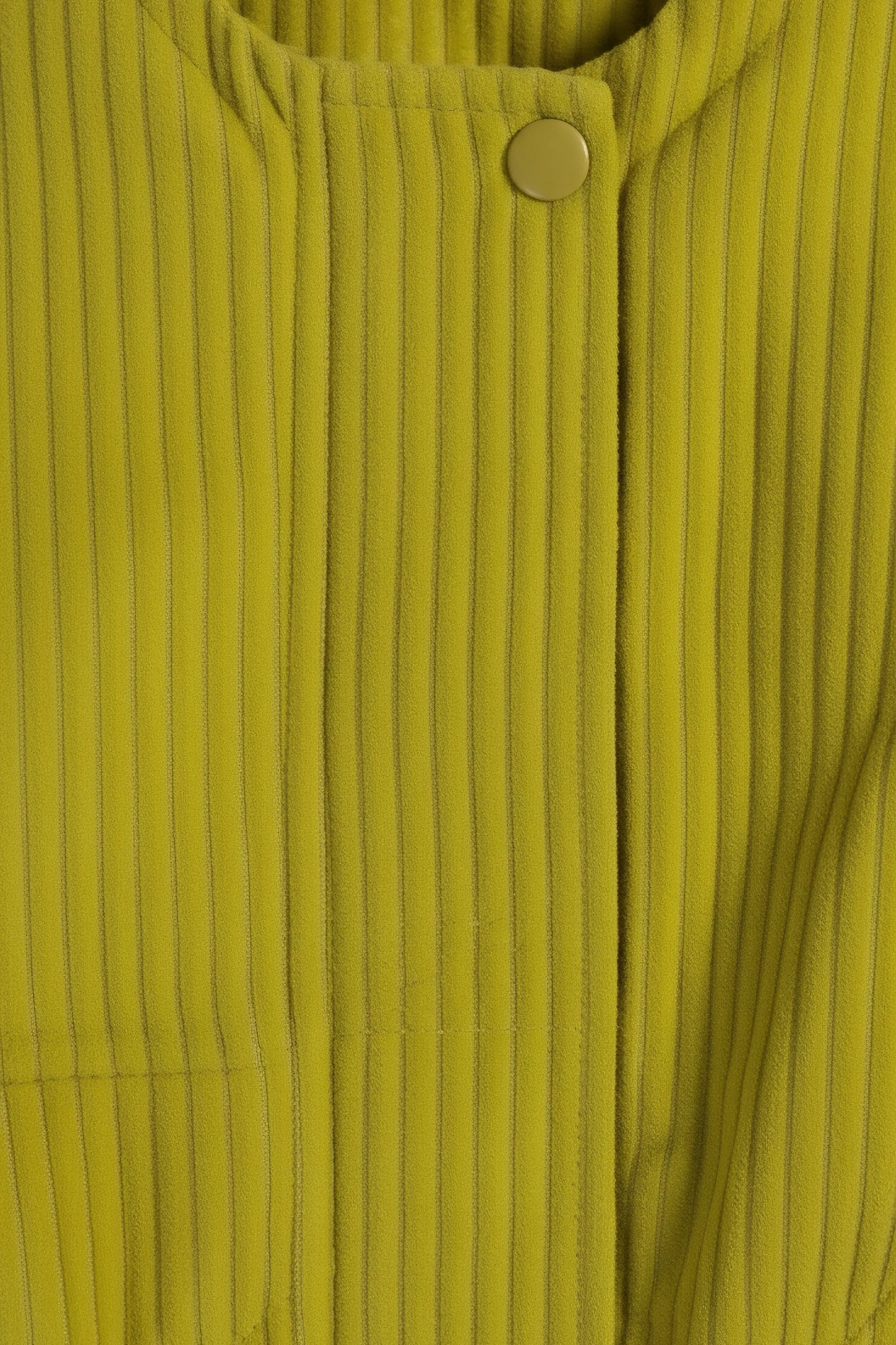 Close-up of a ribbed green fabric with a button detail