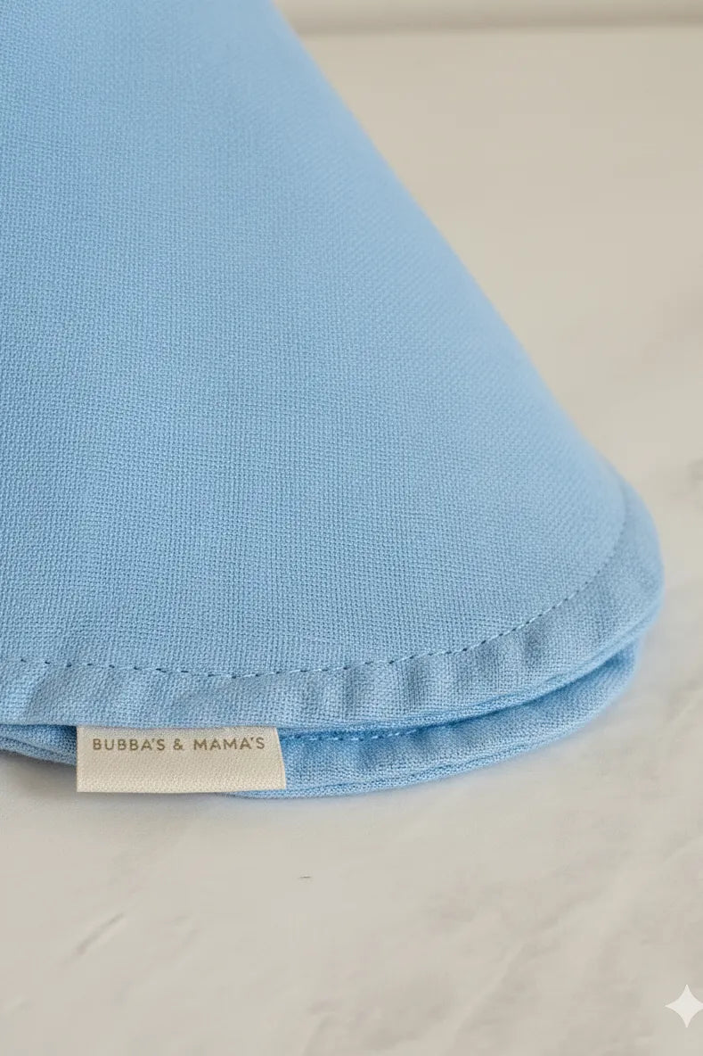 Blue Muslin baby bib with a 'Bubba & Mama' label on a beige background