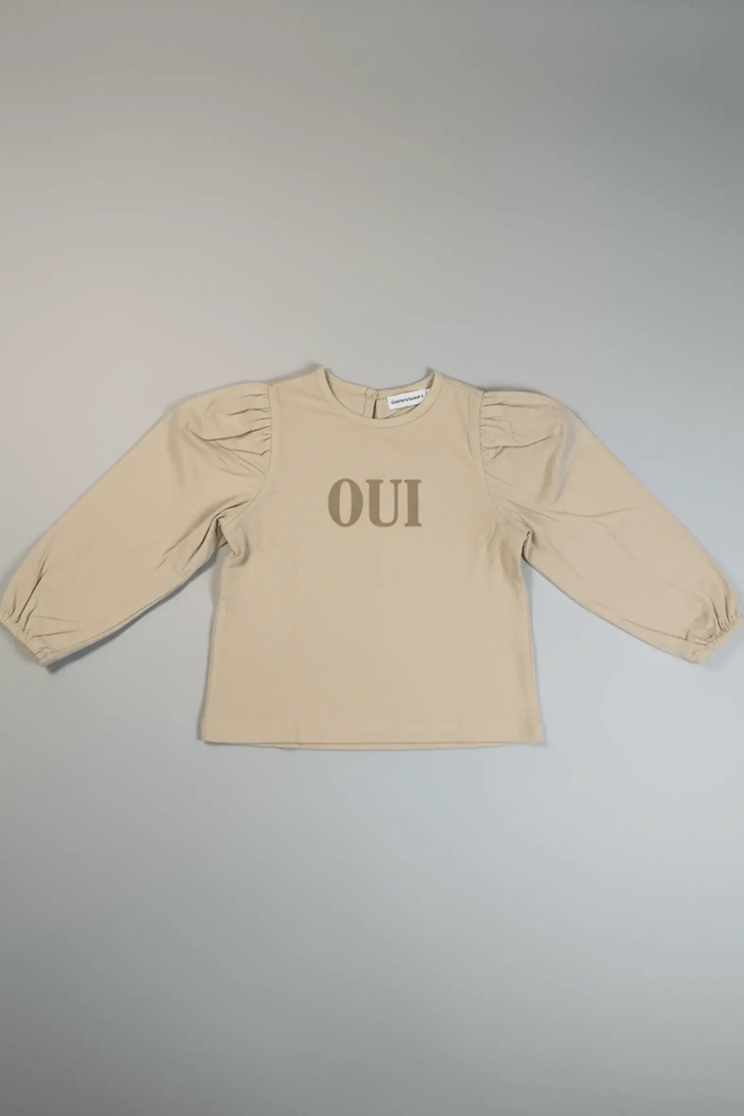 Beige Bubba's and Mama's long-sleeve top with 'OUI' text on a gray background