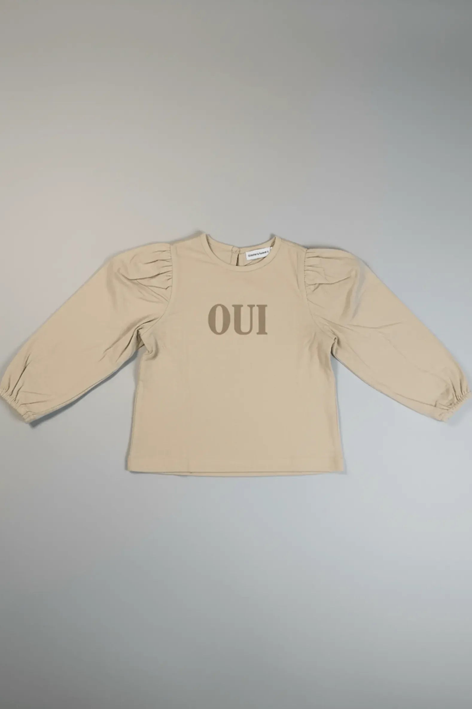 Beige Bubba's and Mama's long-sleeve top with 'OUI' text on a gray background