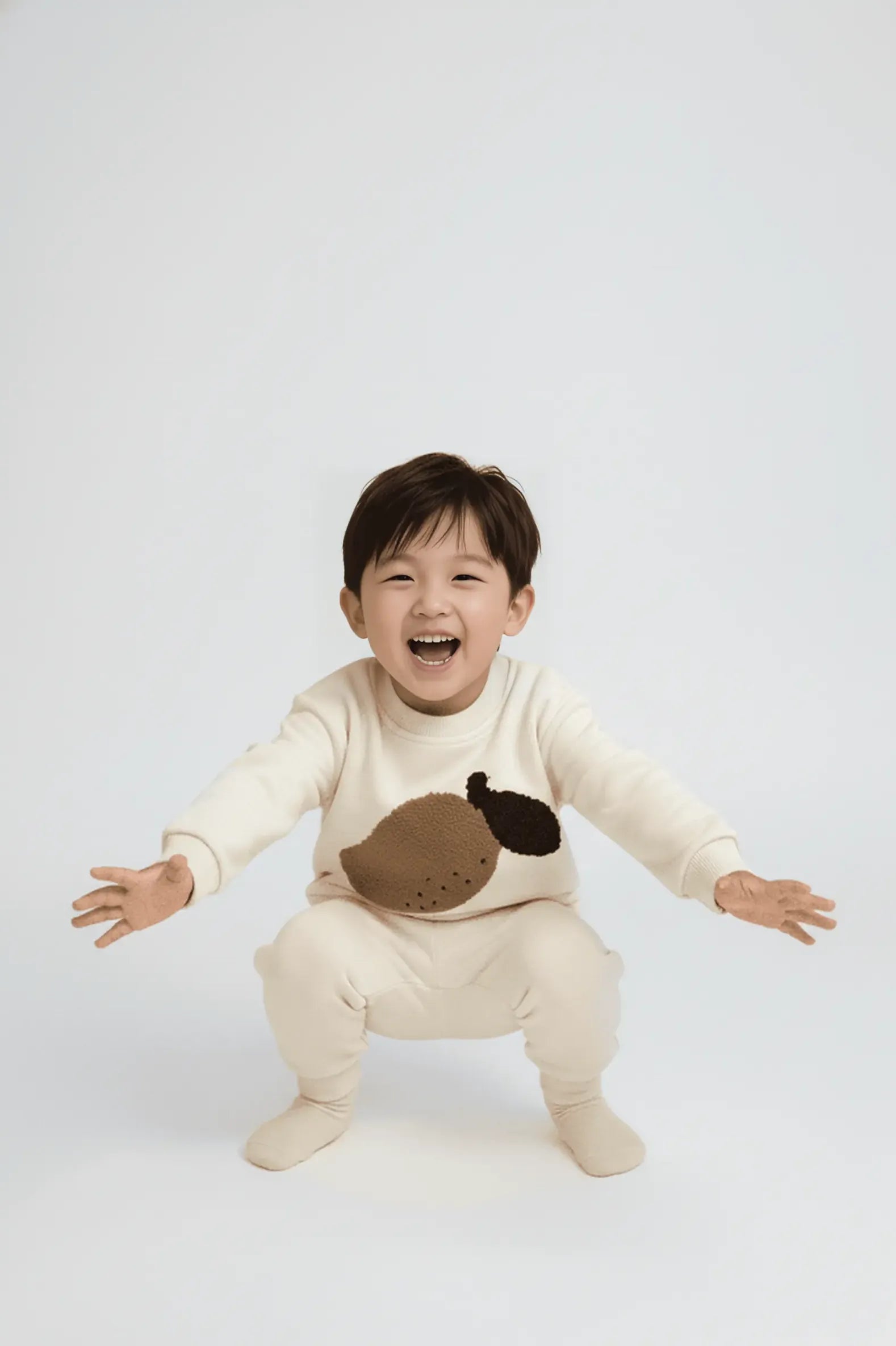 Child wearing a cream-colored  Bubba's and Mama's with a brown design on a white background
