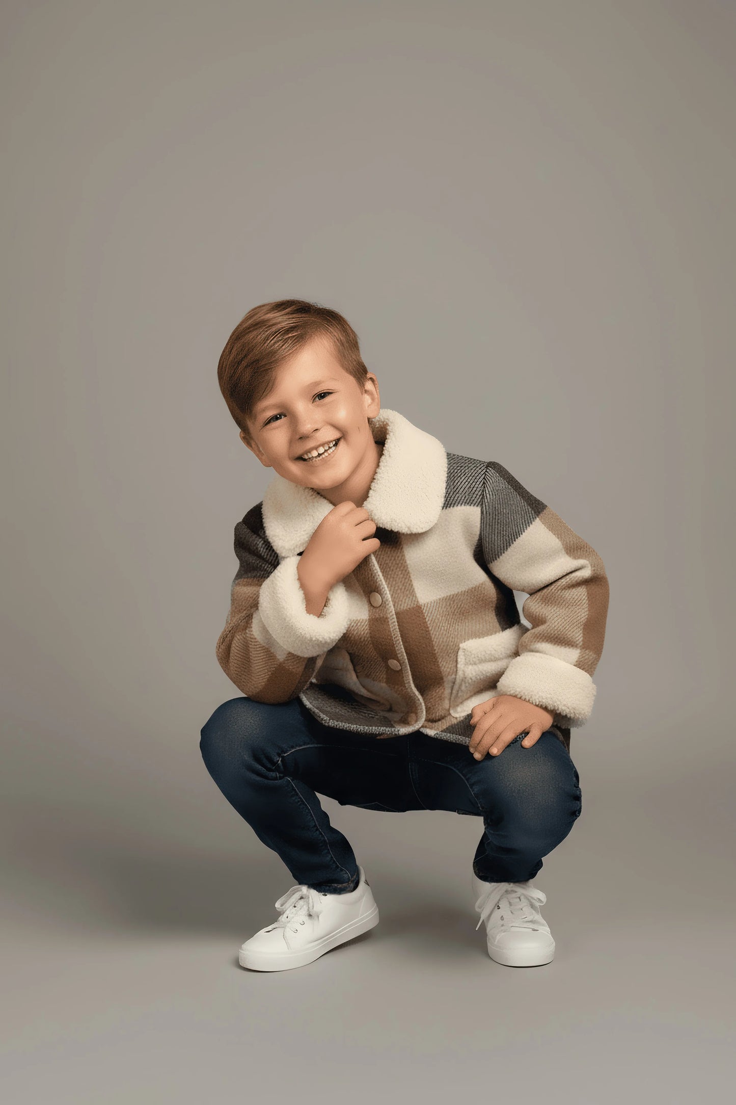 Child wearing a patterned Bubba's and Mama's jacket on a plain background