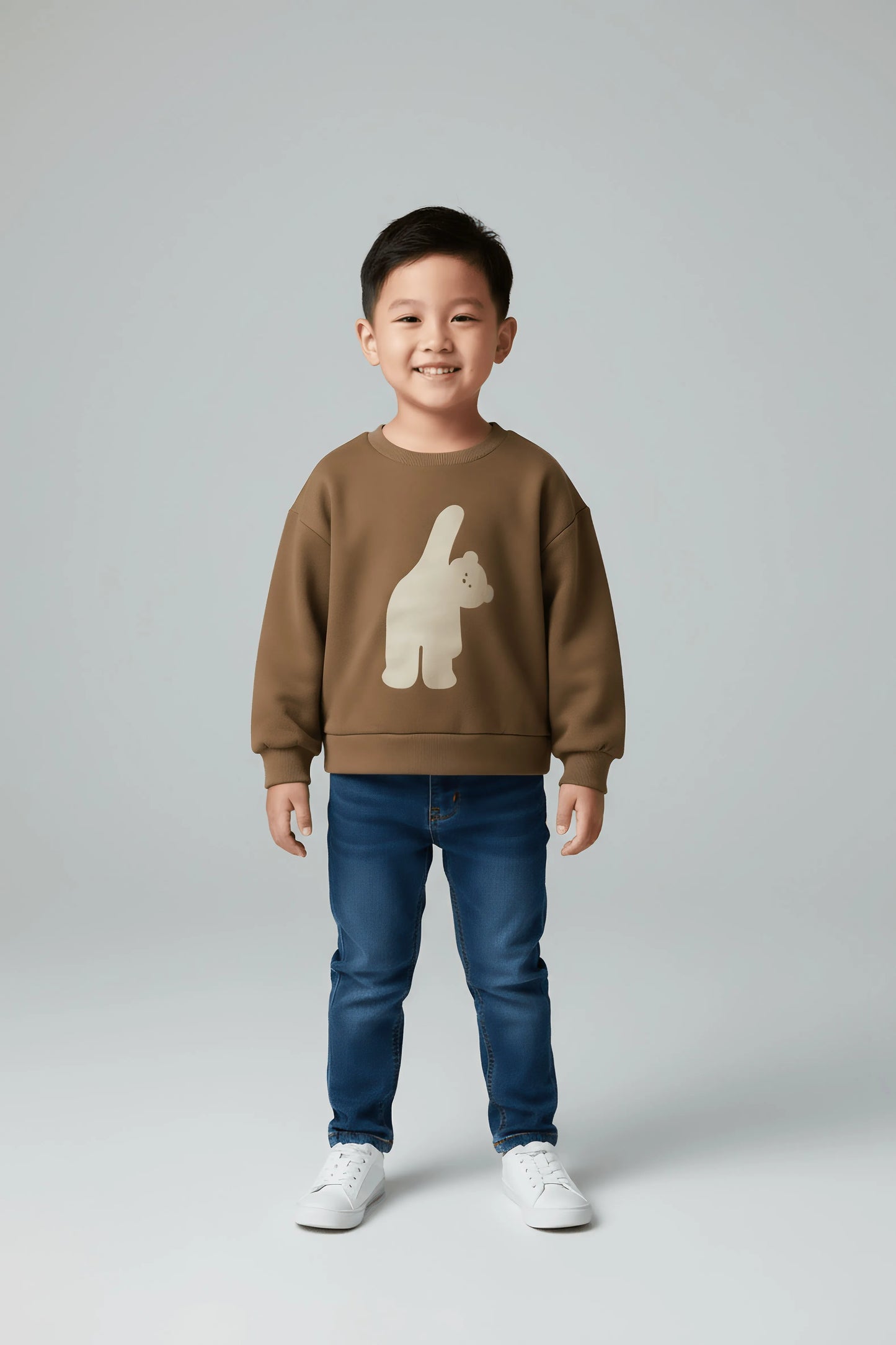 Child wearing a brown Bubba's and Mama's sweatshirt with a bear design and blue jeans on a gray background