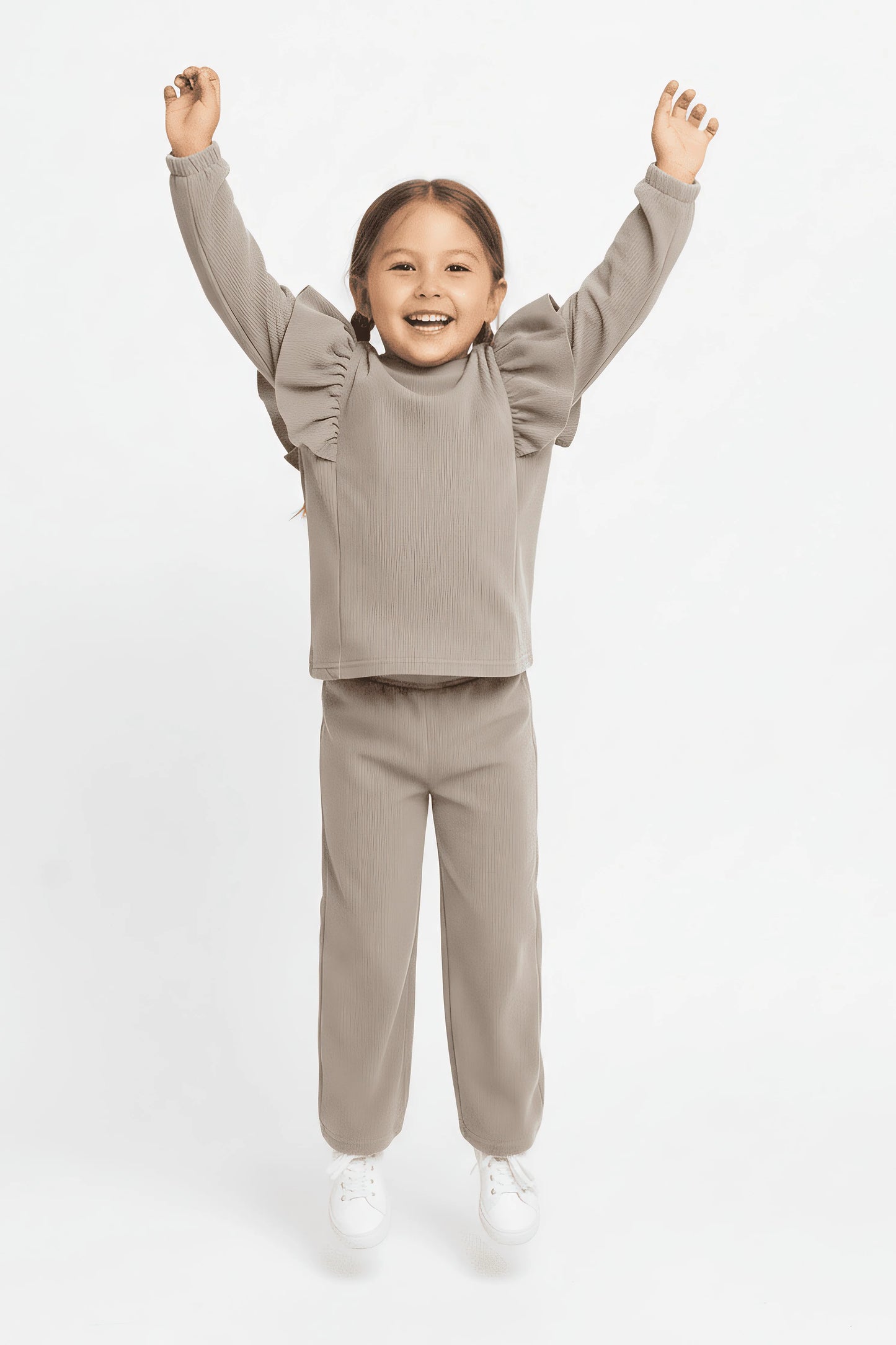 Child wearing a grey Bubba's and Mama's tracksuit with arms raised on a white background