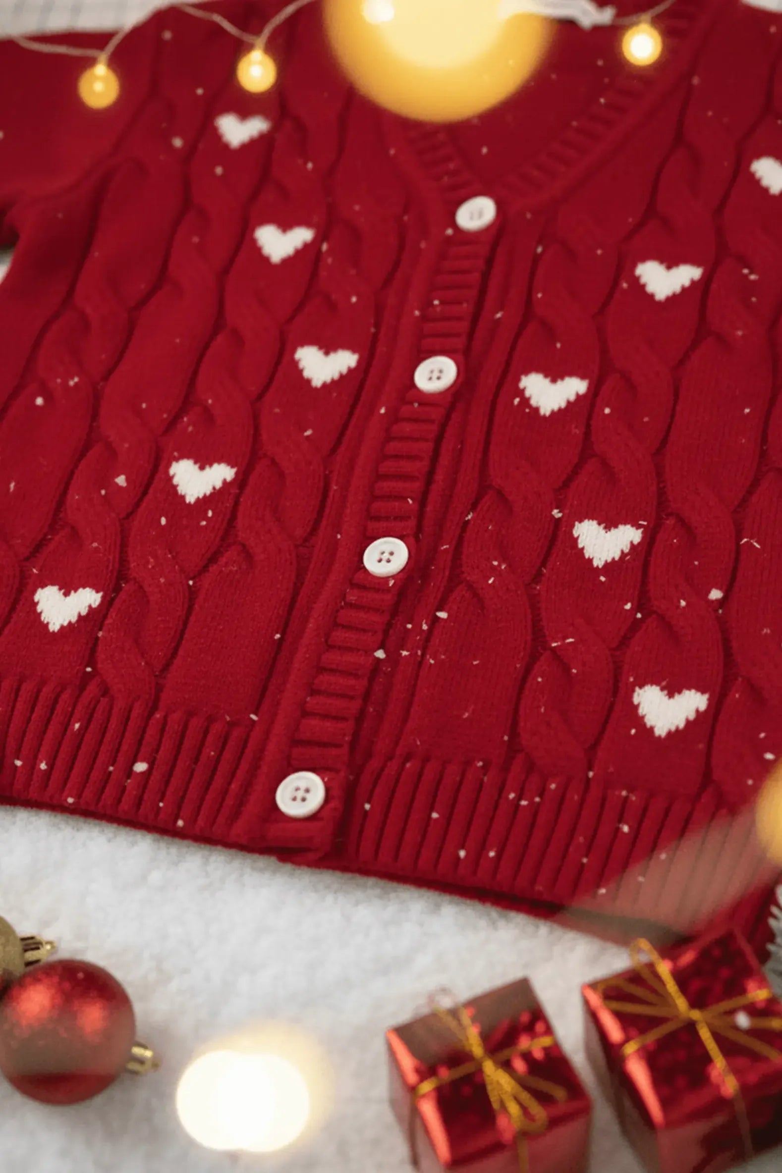 Red Bubba's and Mama's sweater with heart patterns on a light background with Christmas decorations.
