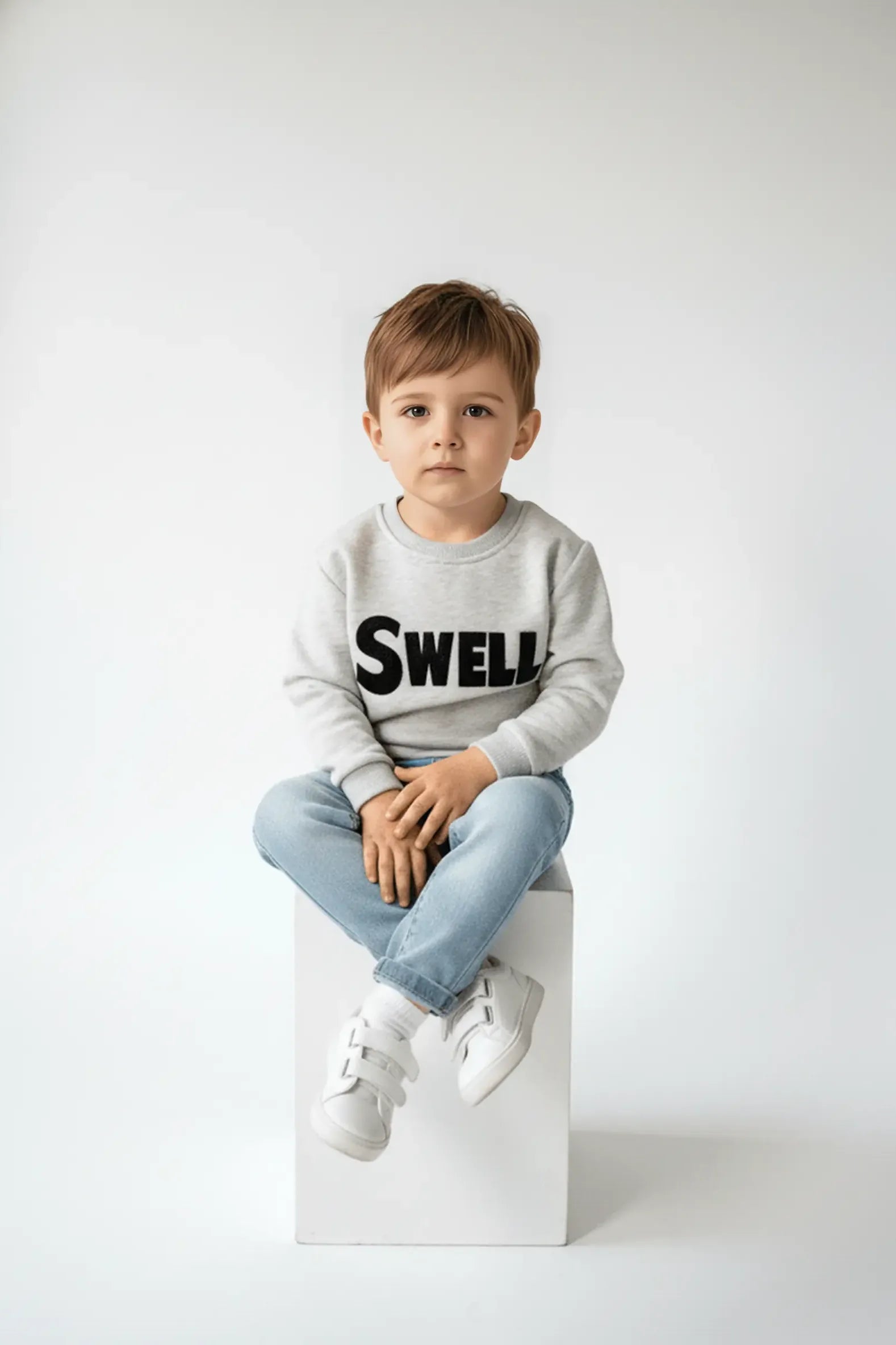 Child wearing a Bubba's and Mama's gray sweatshirt with 'SWELL' text on a white background