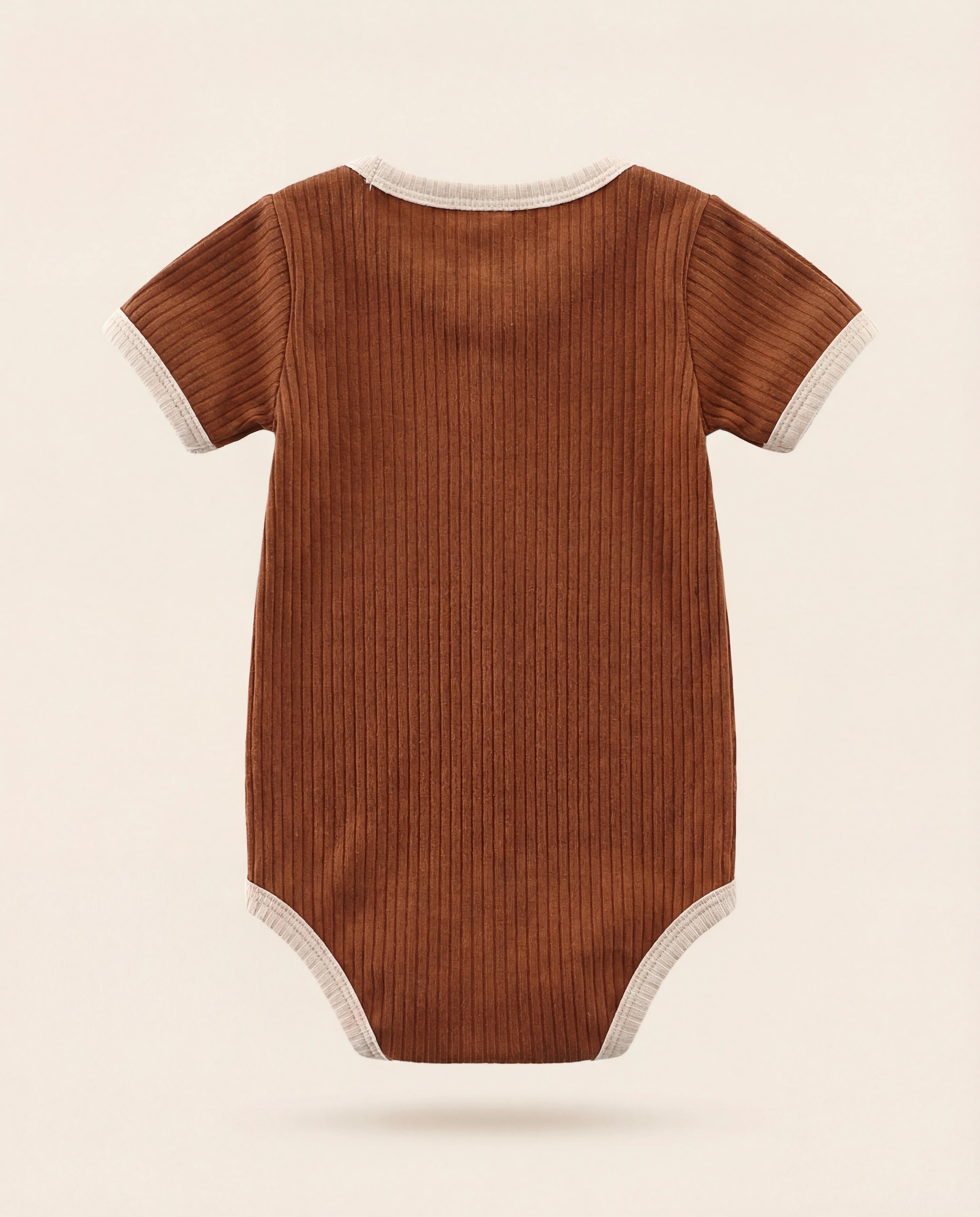 Brown ribbed baby onesie on a beige background