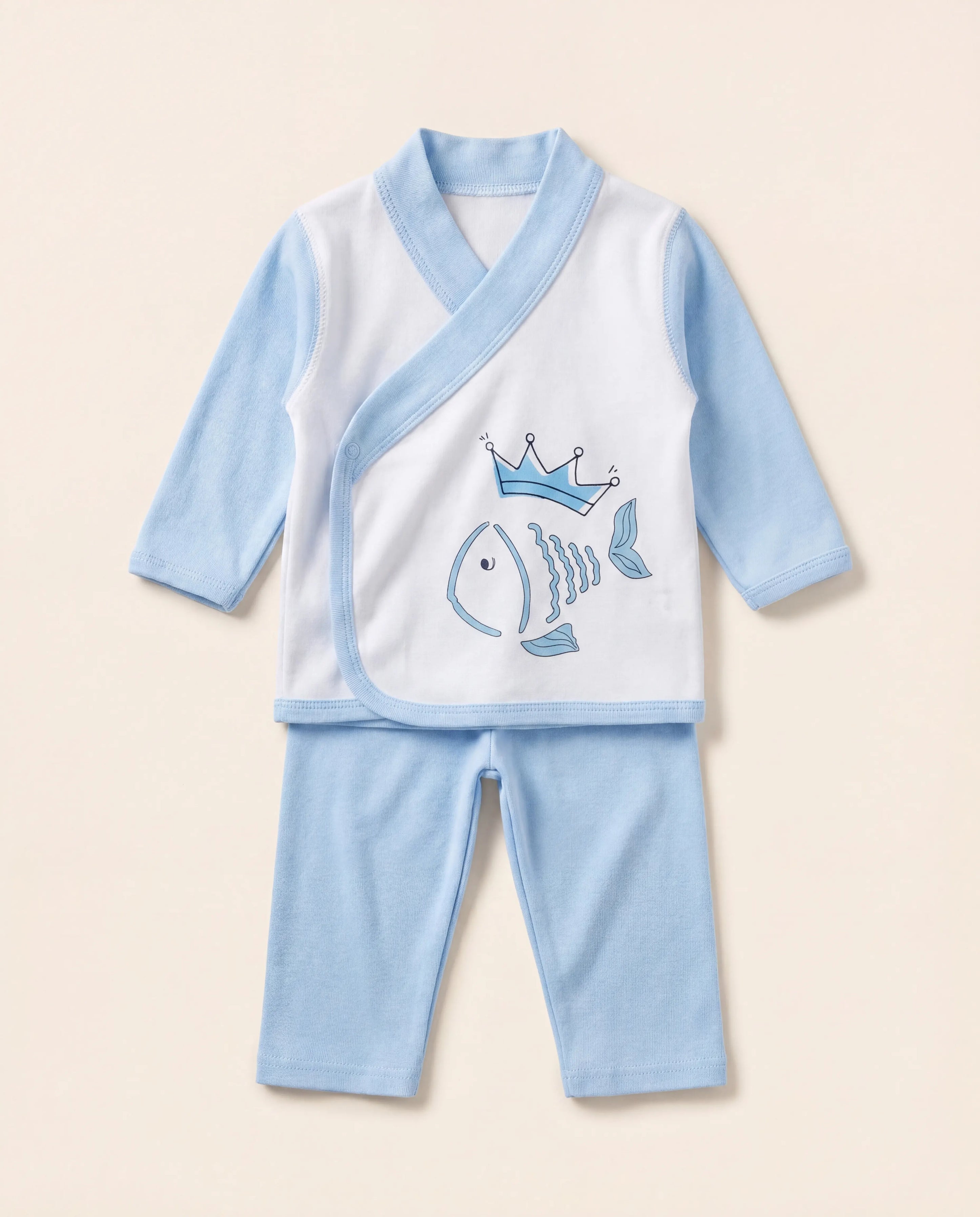 Baby outfit with white shirt and blue pants featuring a fish design on a beige background