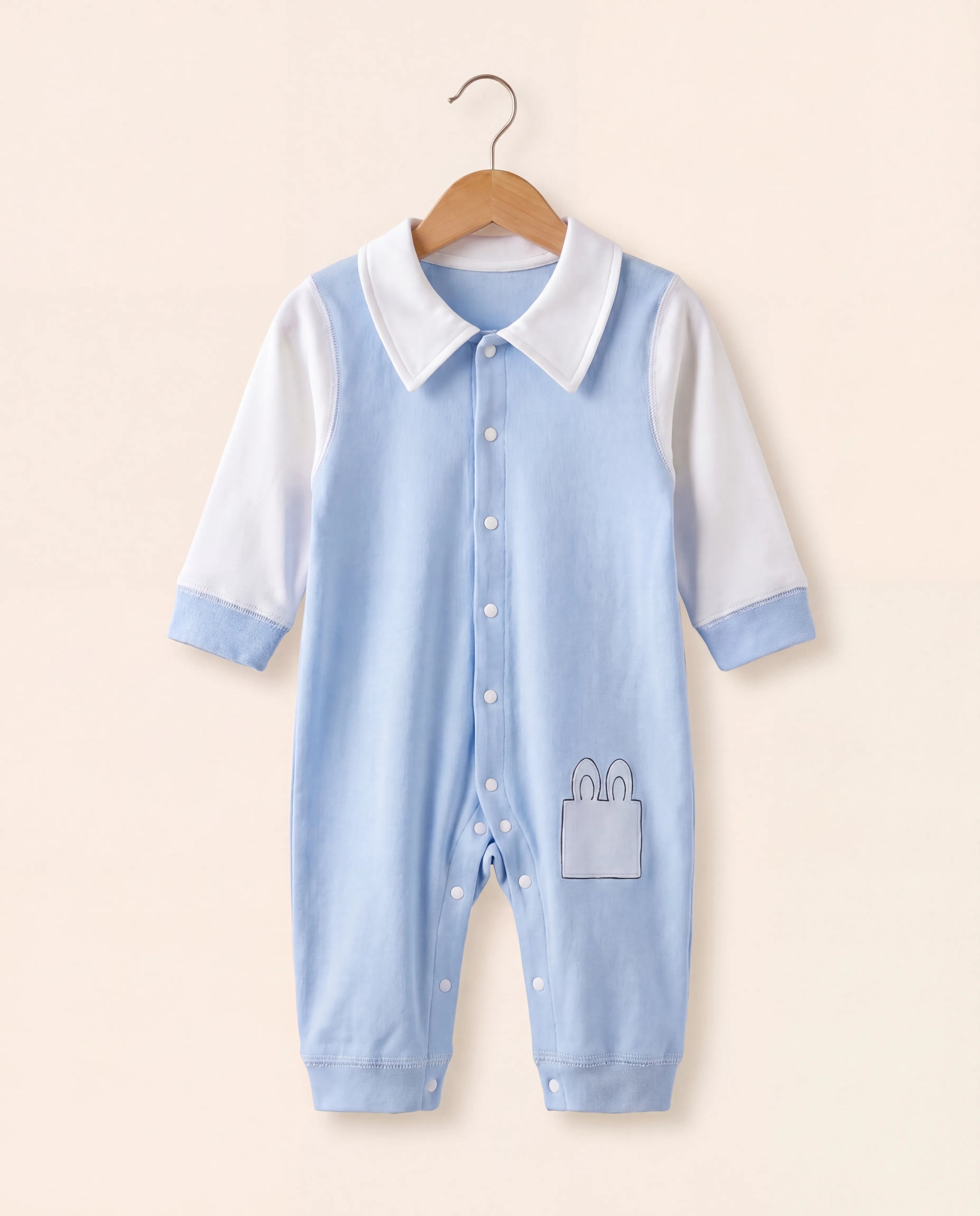 Light blue baby romper with white collar on a beige background