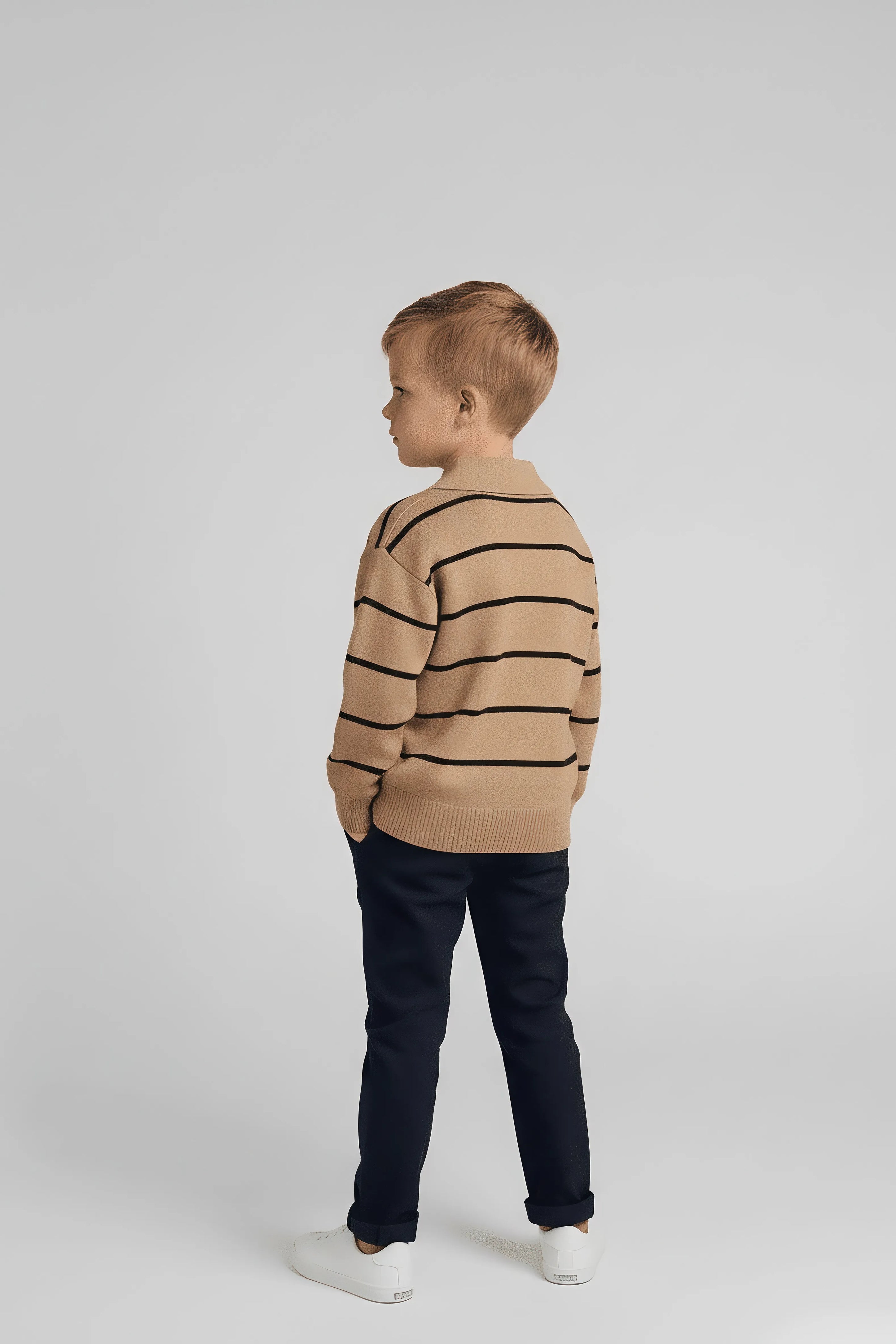 Child wearing a brown Bubba's and Mama's sweater with black stripes on a white background