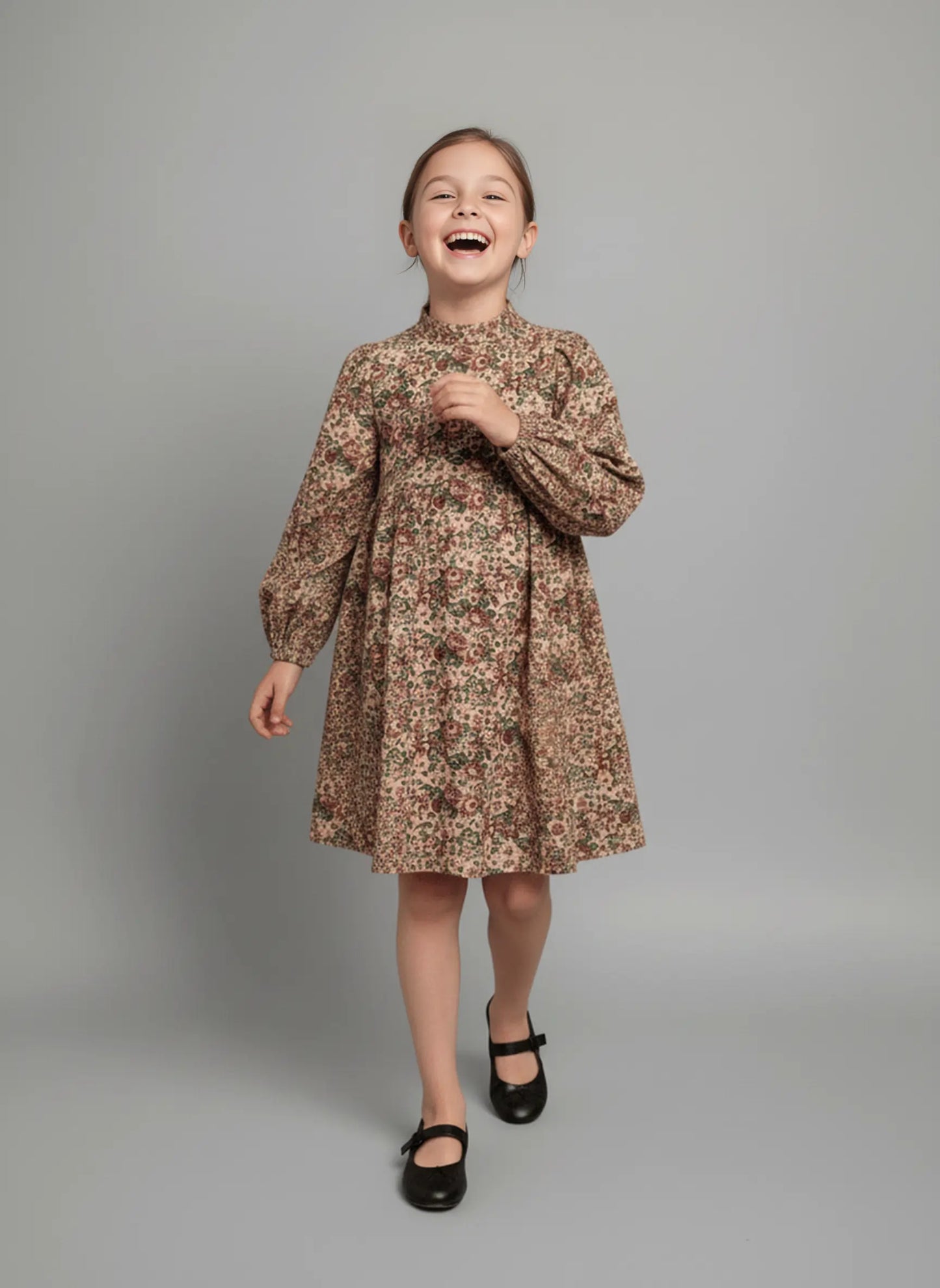 Young girl wearing a floral dress against a plain background